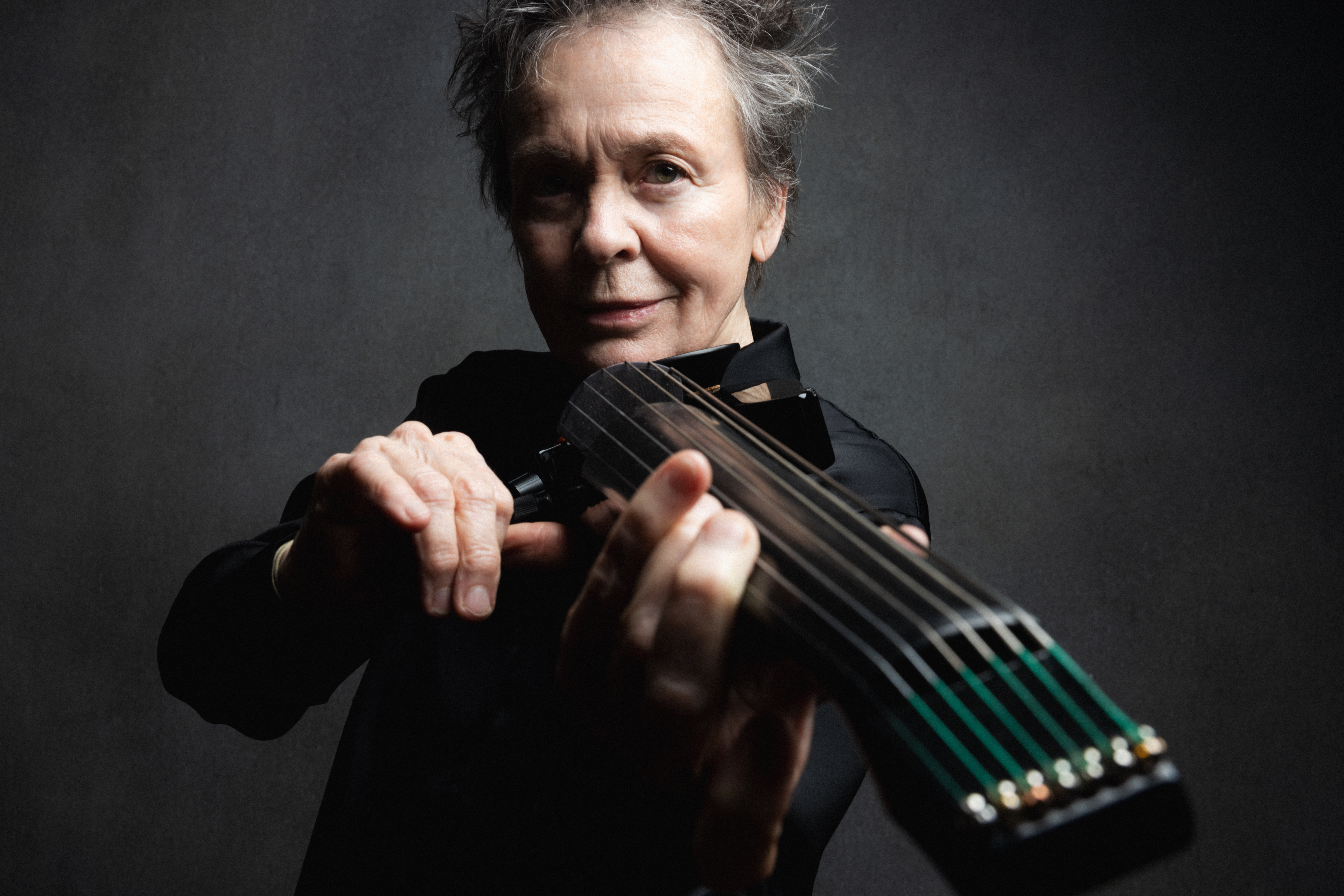 Laurie Anderson holding instrument