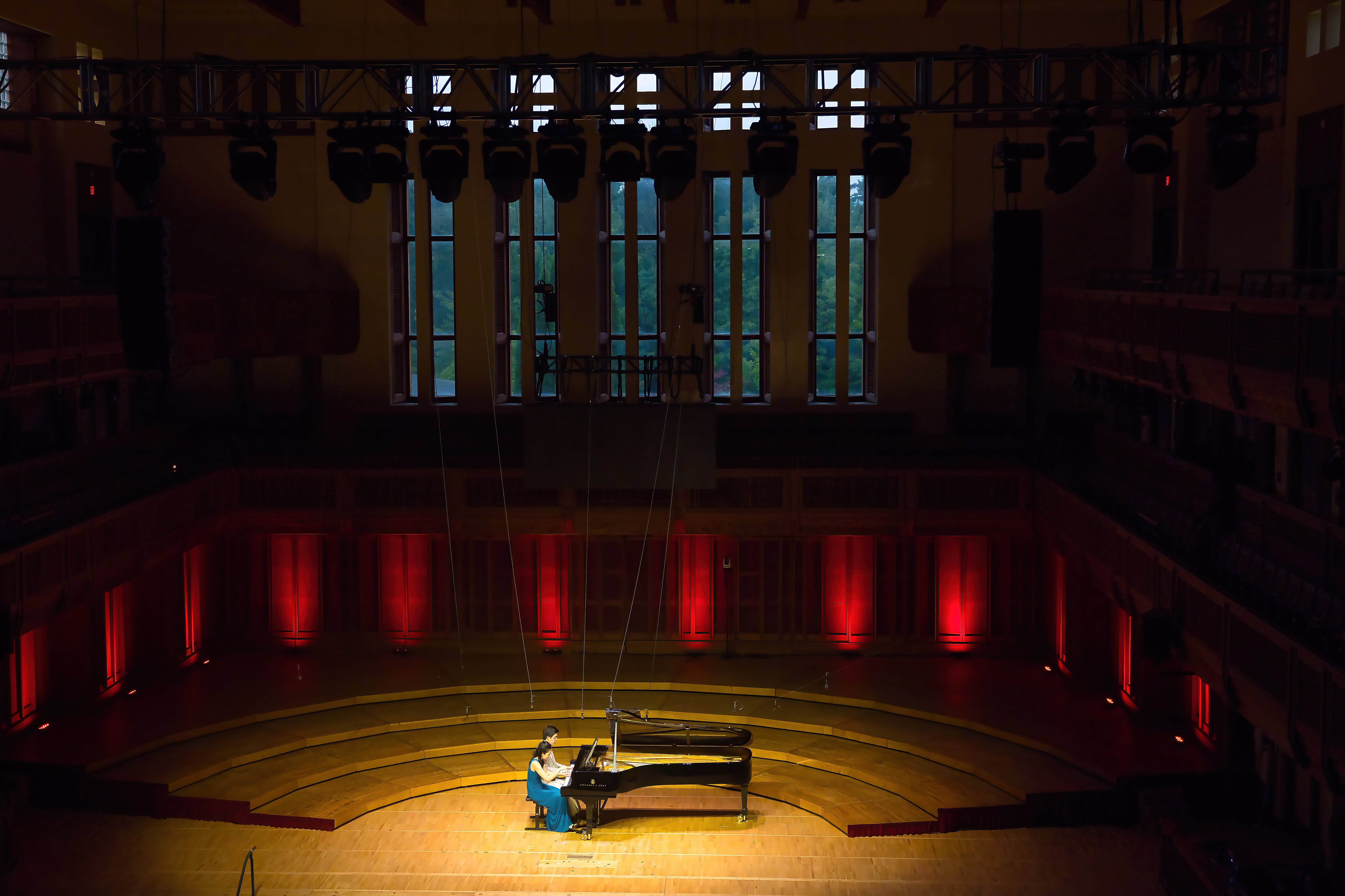 Two pianists perform on one piano during the opening concert of the festival of contemporary music