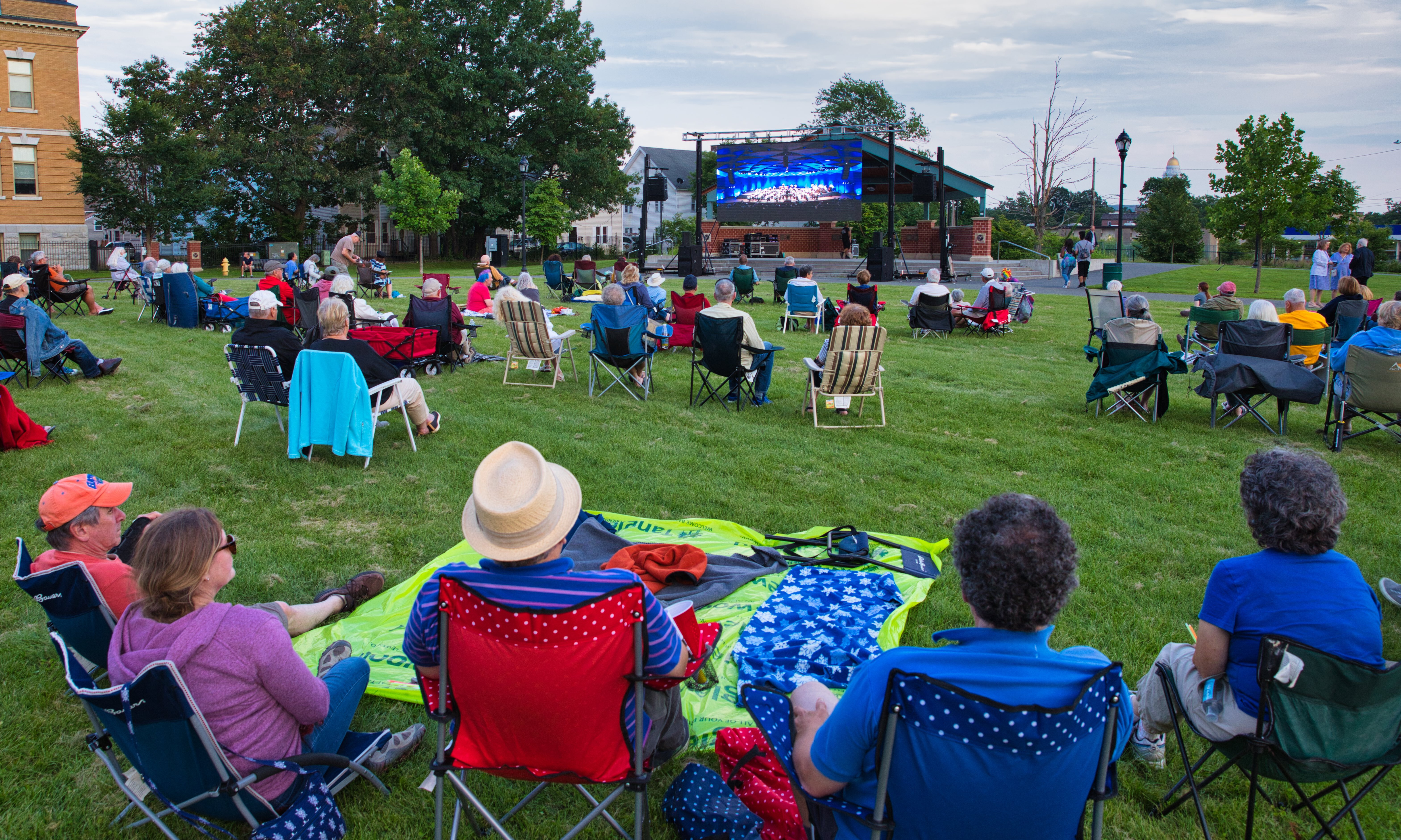 People on lawn chairs enjoy music outdoors