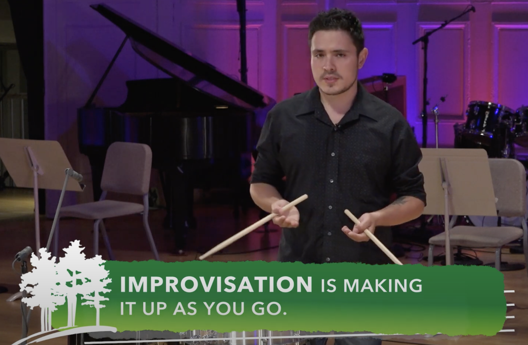 A man with drumsticks and a drum