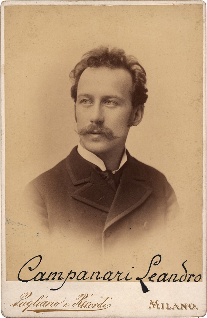 Headshot of a man with slightly curly hair and mustache