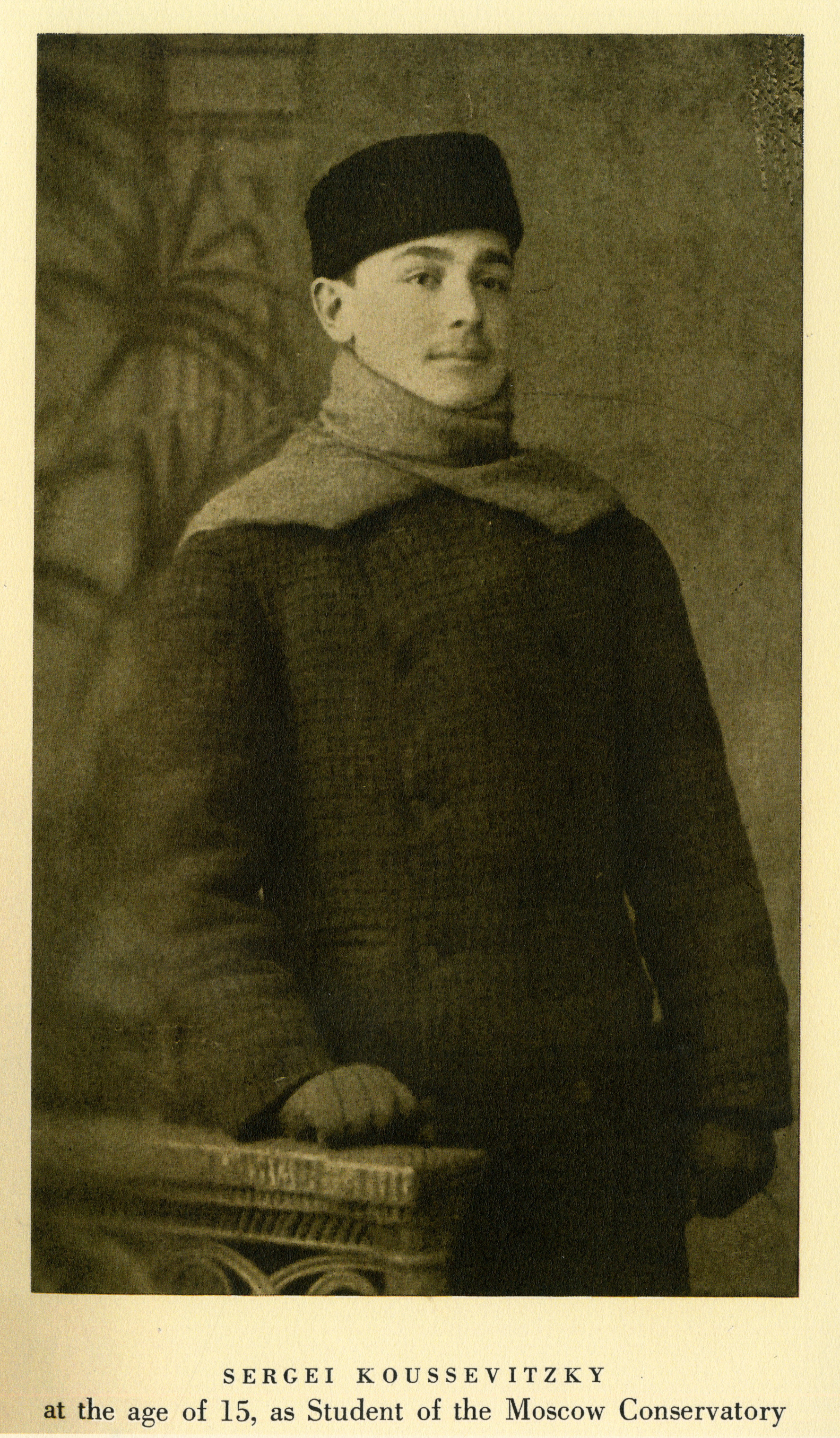 Teenage Serge Koussevitzky is dressed in heavy coat, scarf and hat