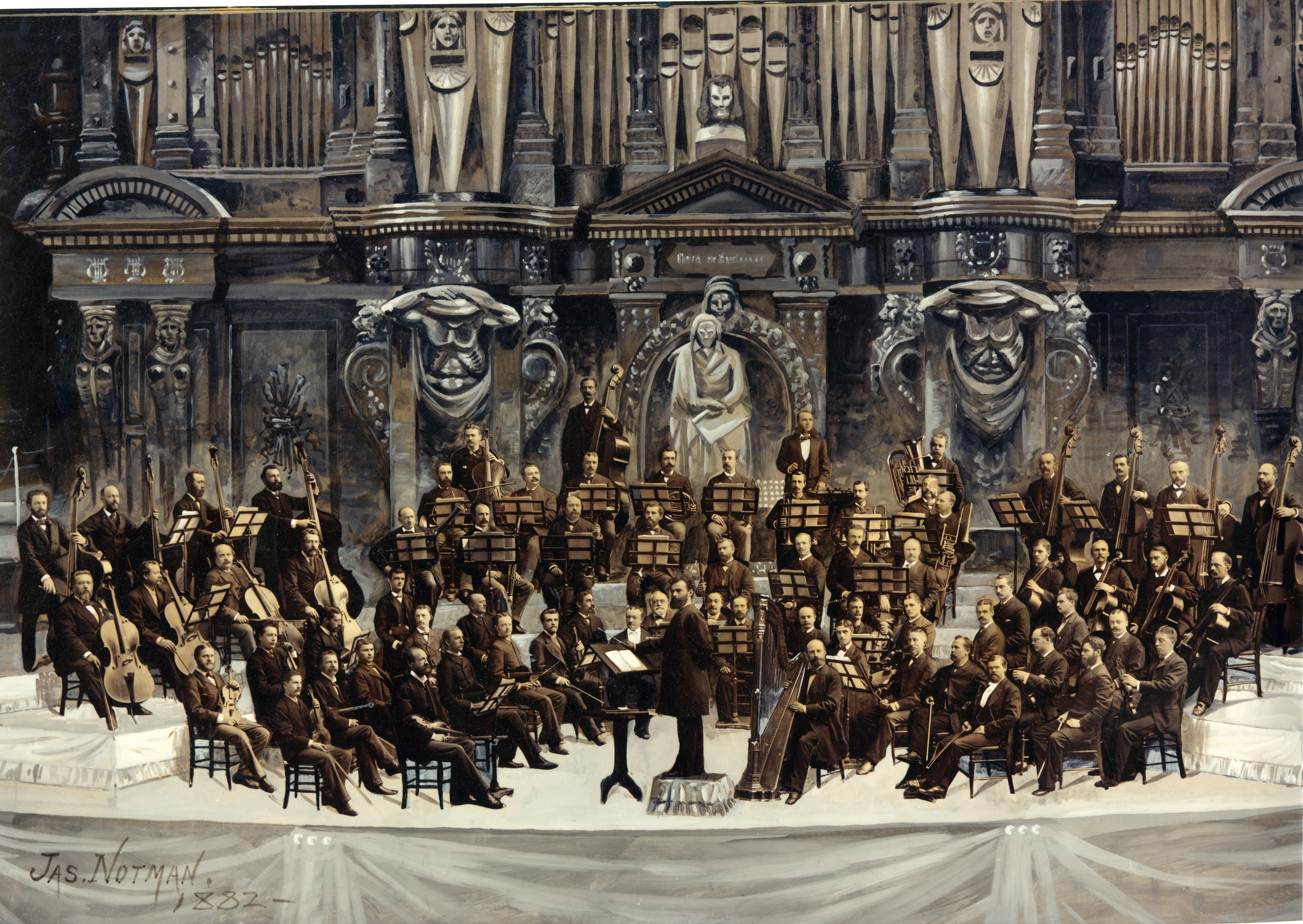 A painting of a bearded man stands in the center of a group of orchestra musicians on an ornate stage