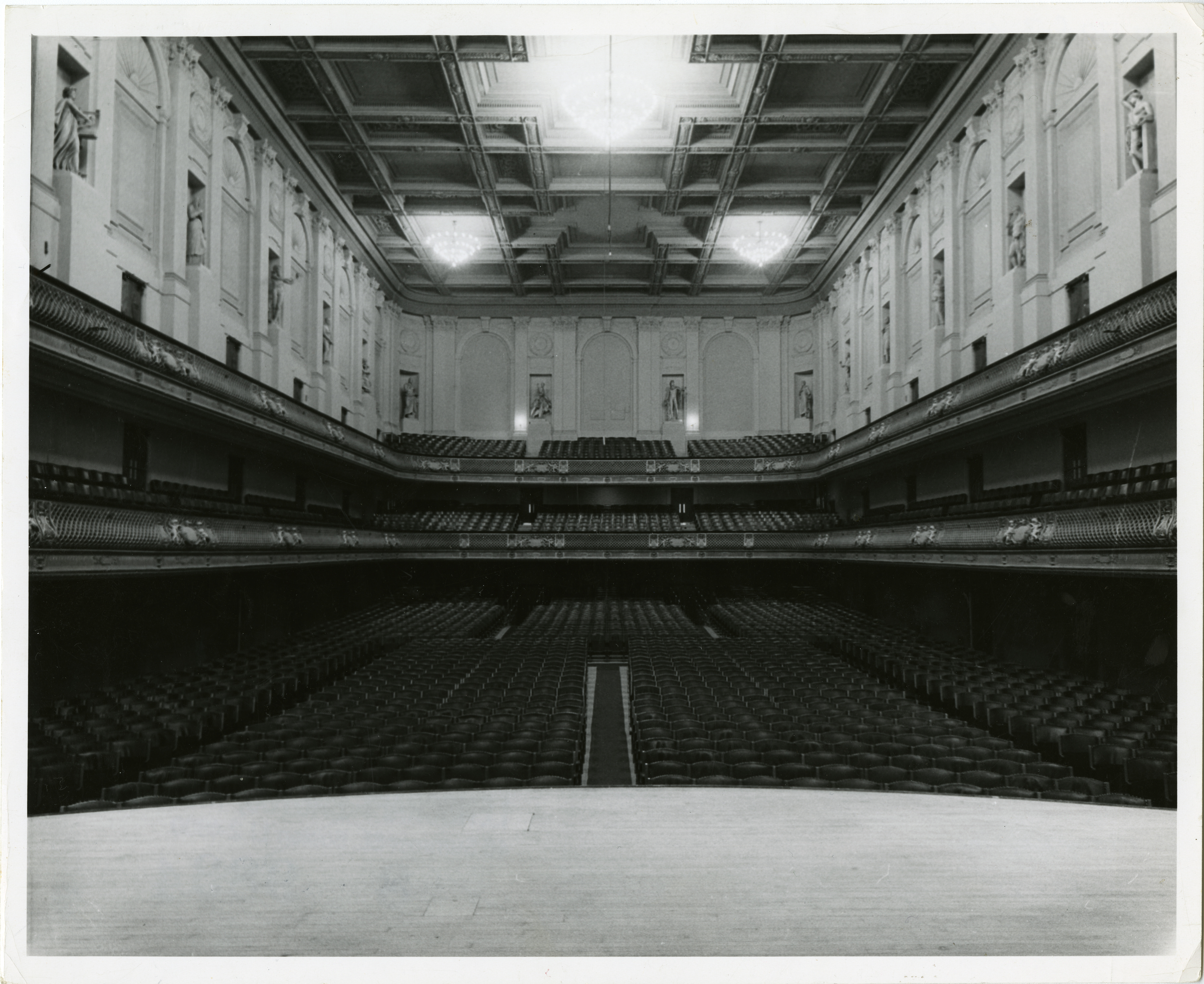 View from empty stage of the Symphony Hall auditorium with no audience, the seats slope upwards on the raked flooring