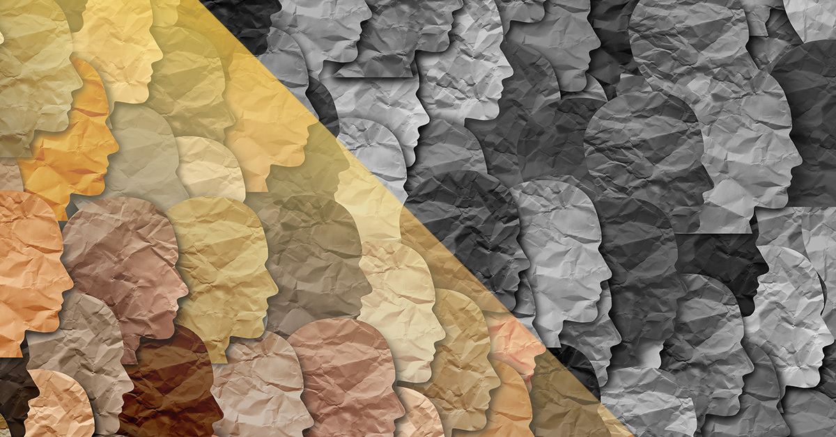 Different colored head profiles cut out of paper in a collage.