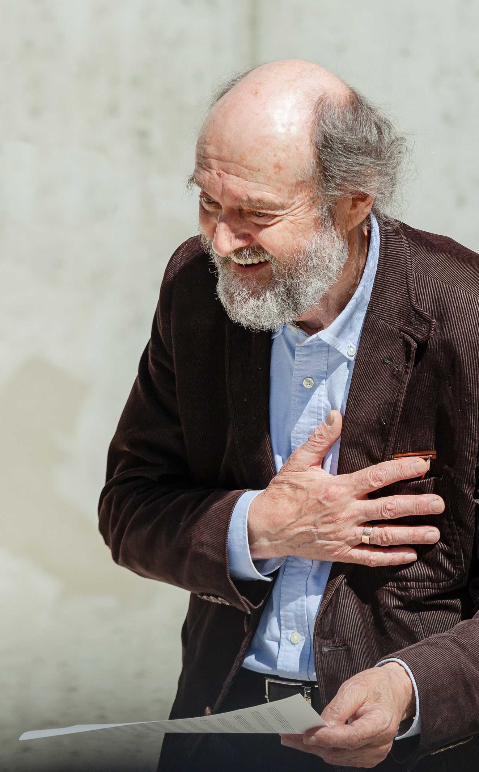 Arvo Pärt holding a paper and smiling