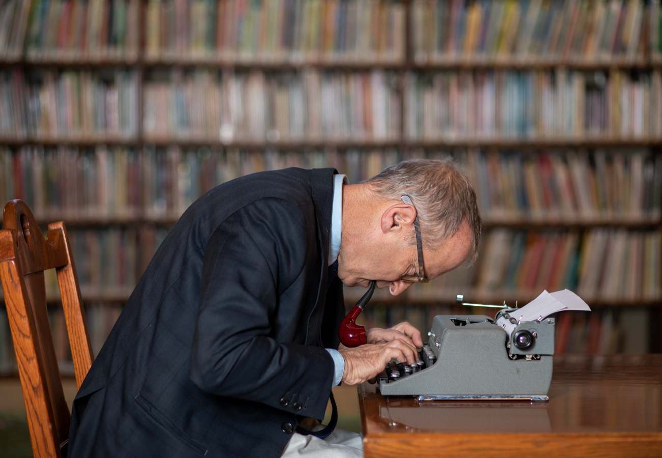 David Sedaris leaning over a typwriter