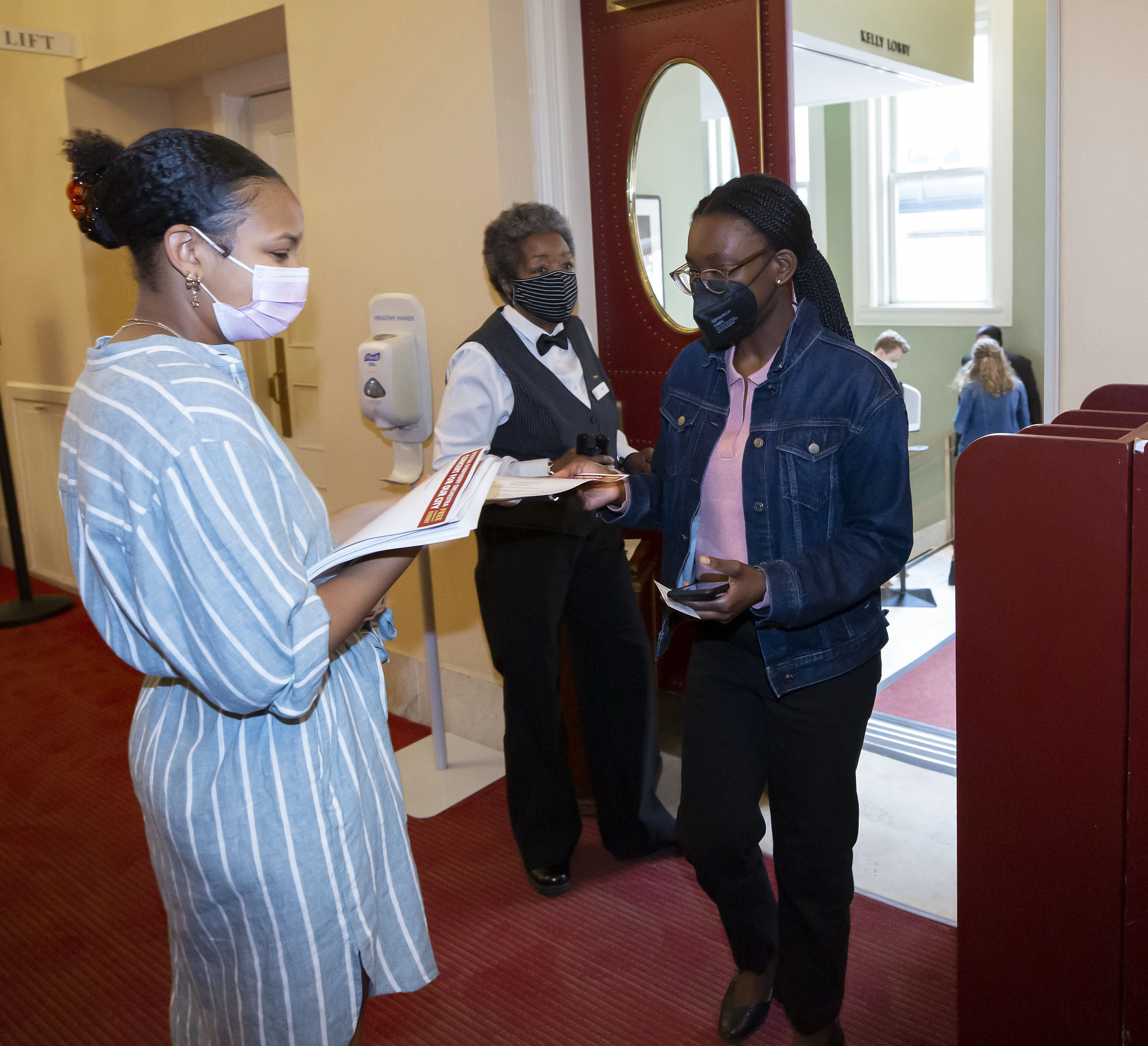 An usher and ticket taker greet a member of the audience at the door of Symphony Hall