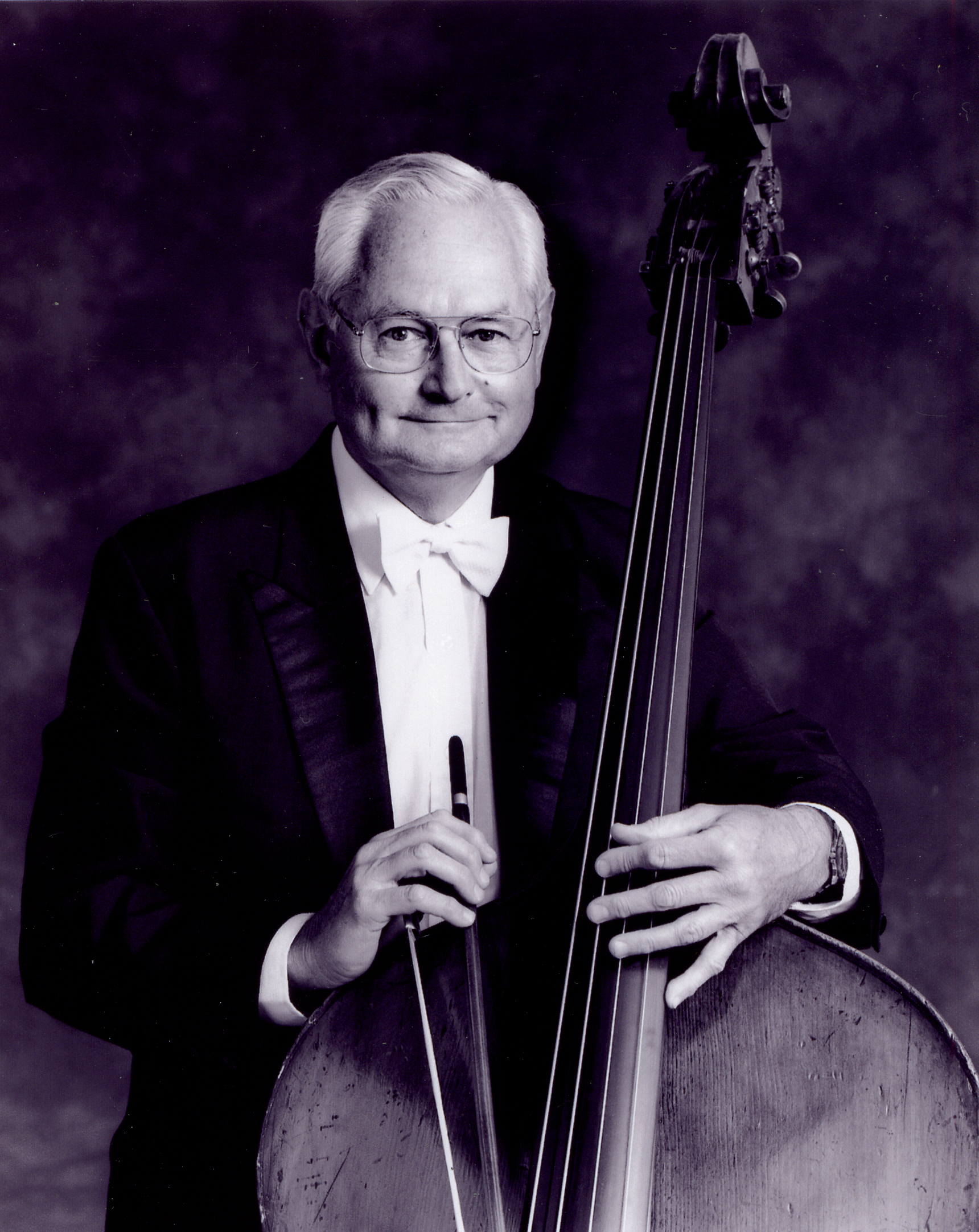 Bassist John Salkowski in tuxedo holding his double bass