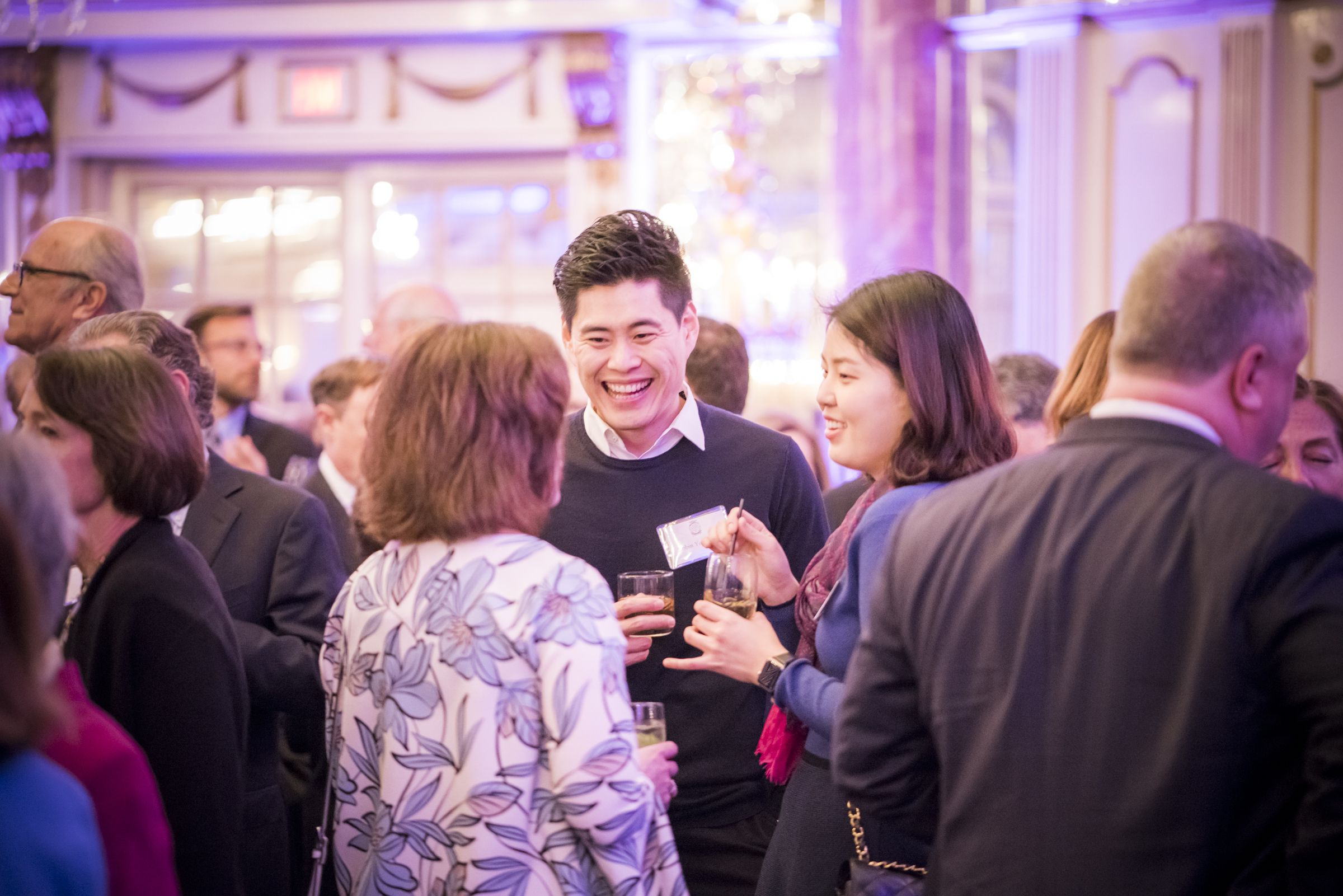 patrons drinking mixed drinks and smiling at an event in symphony hall in Boston.