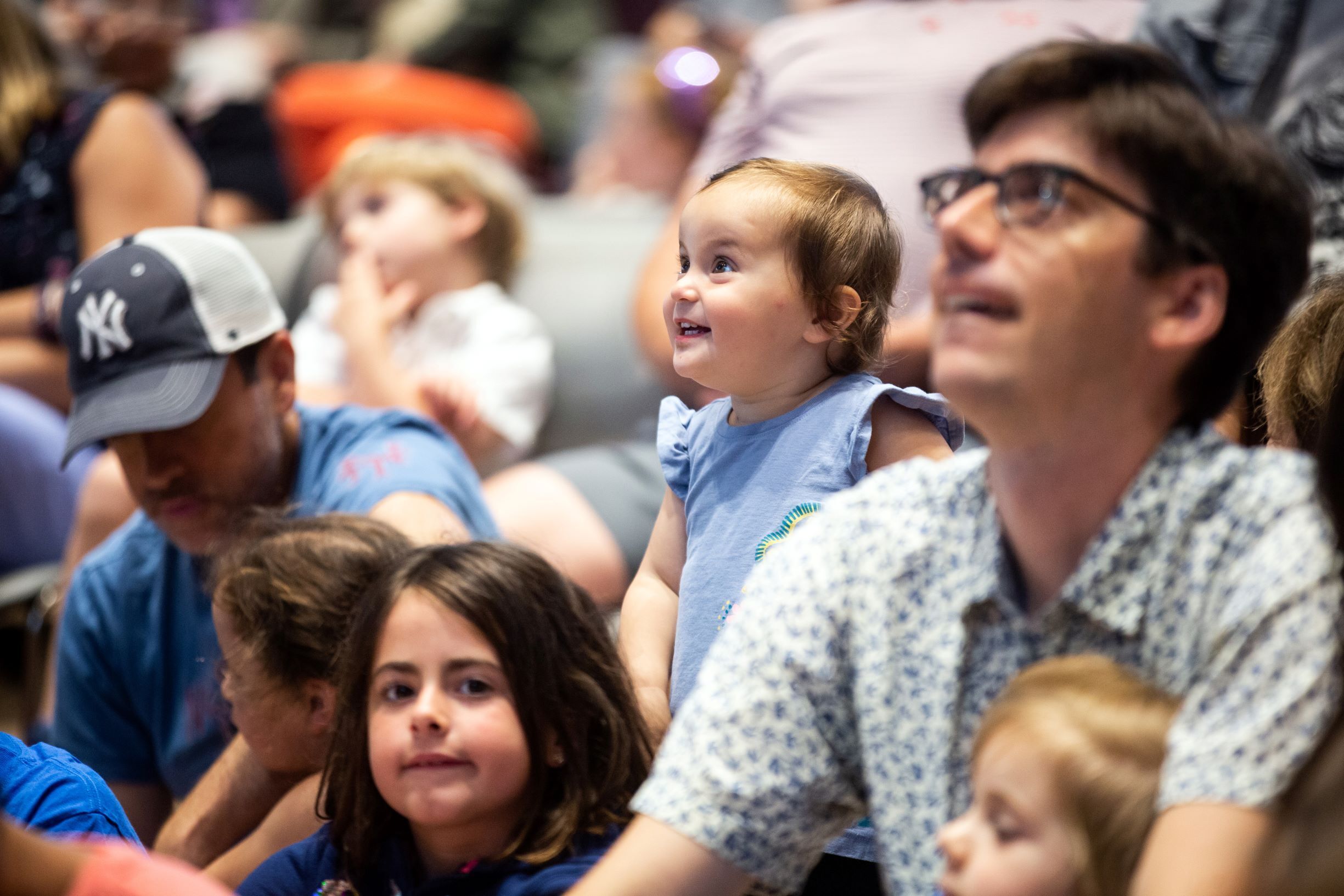 Children and parents watching a performance with excitement.