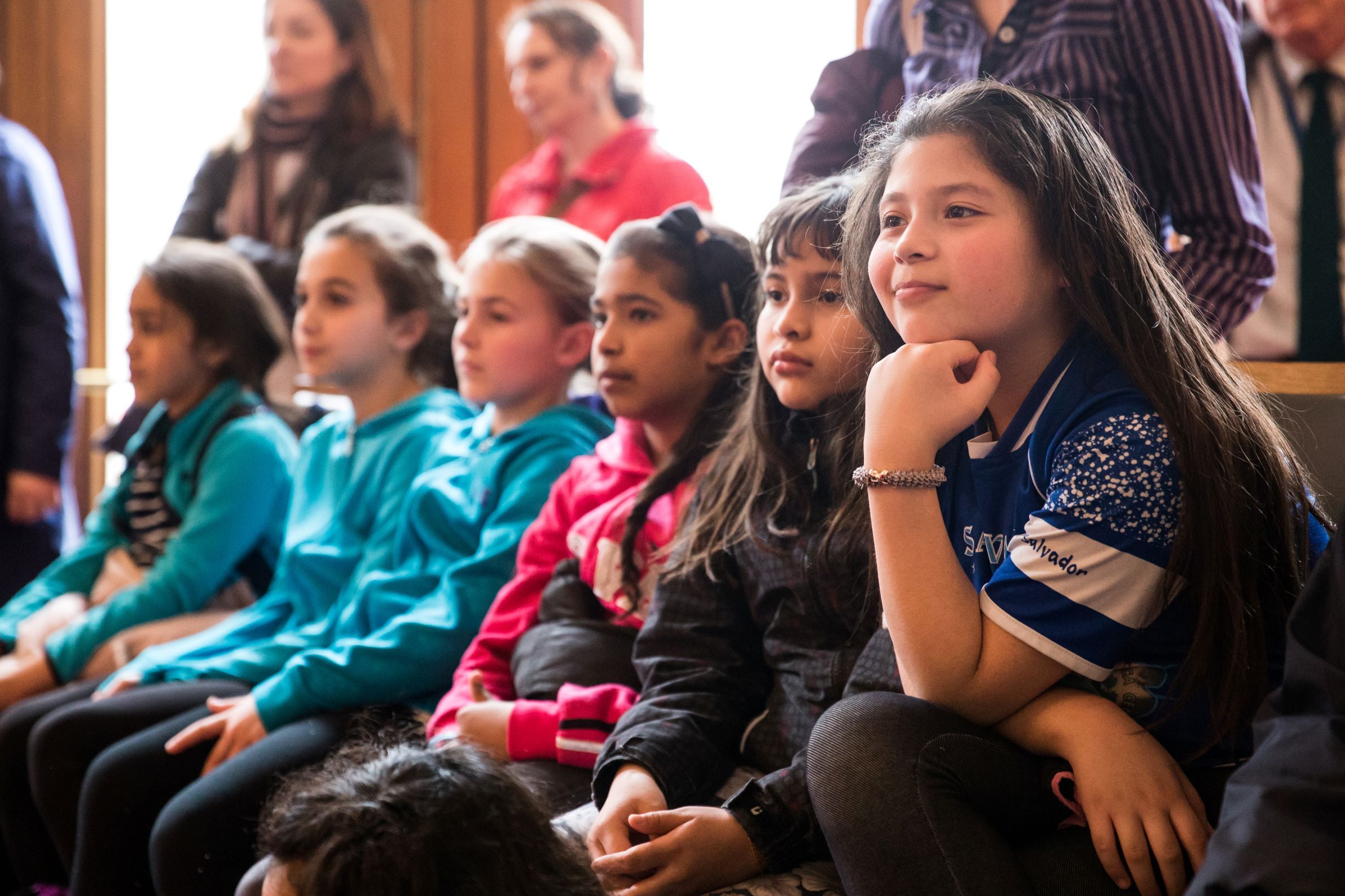 A row of students listening to a performance.