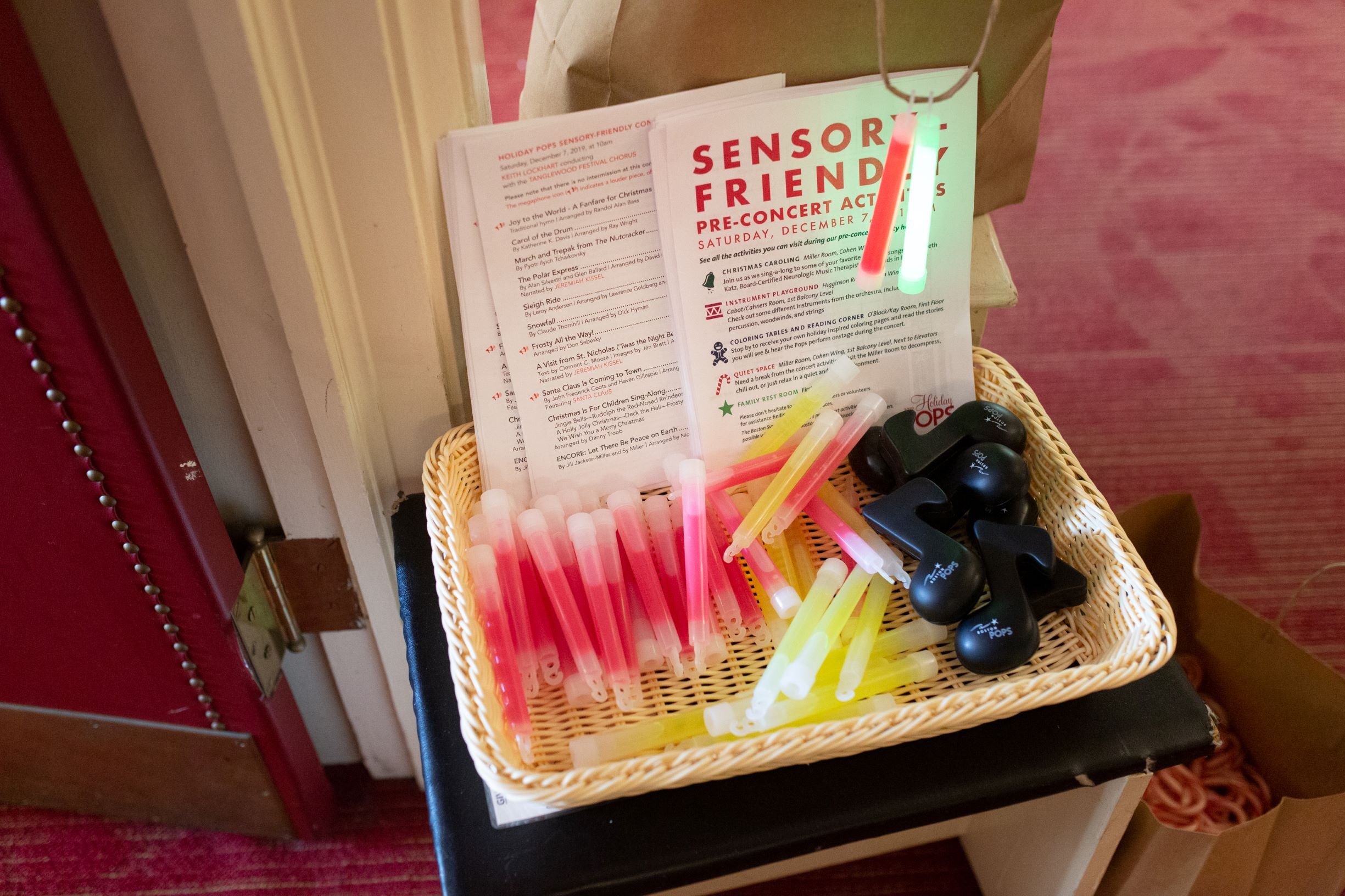 A basket of sensory friendly pamphlets and supplies, including glow sticks.