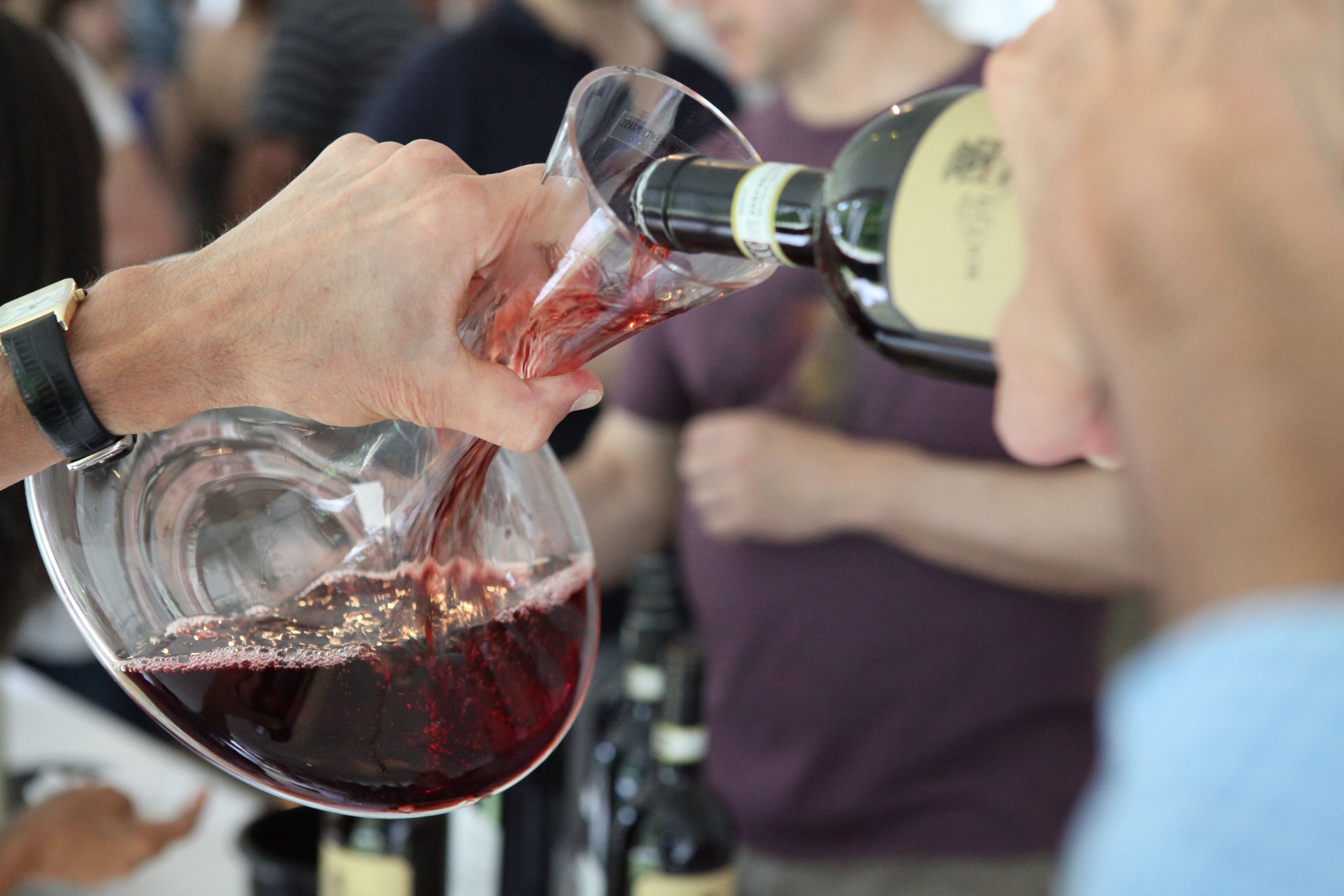 Close up of red wine being poured from a bottle into a glass