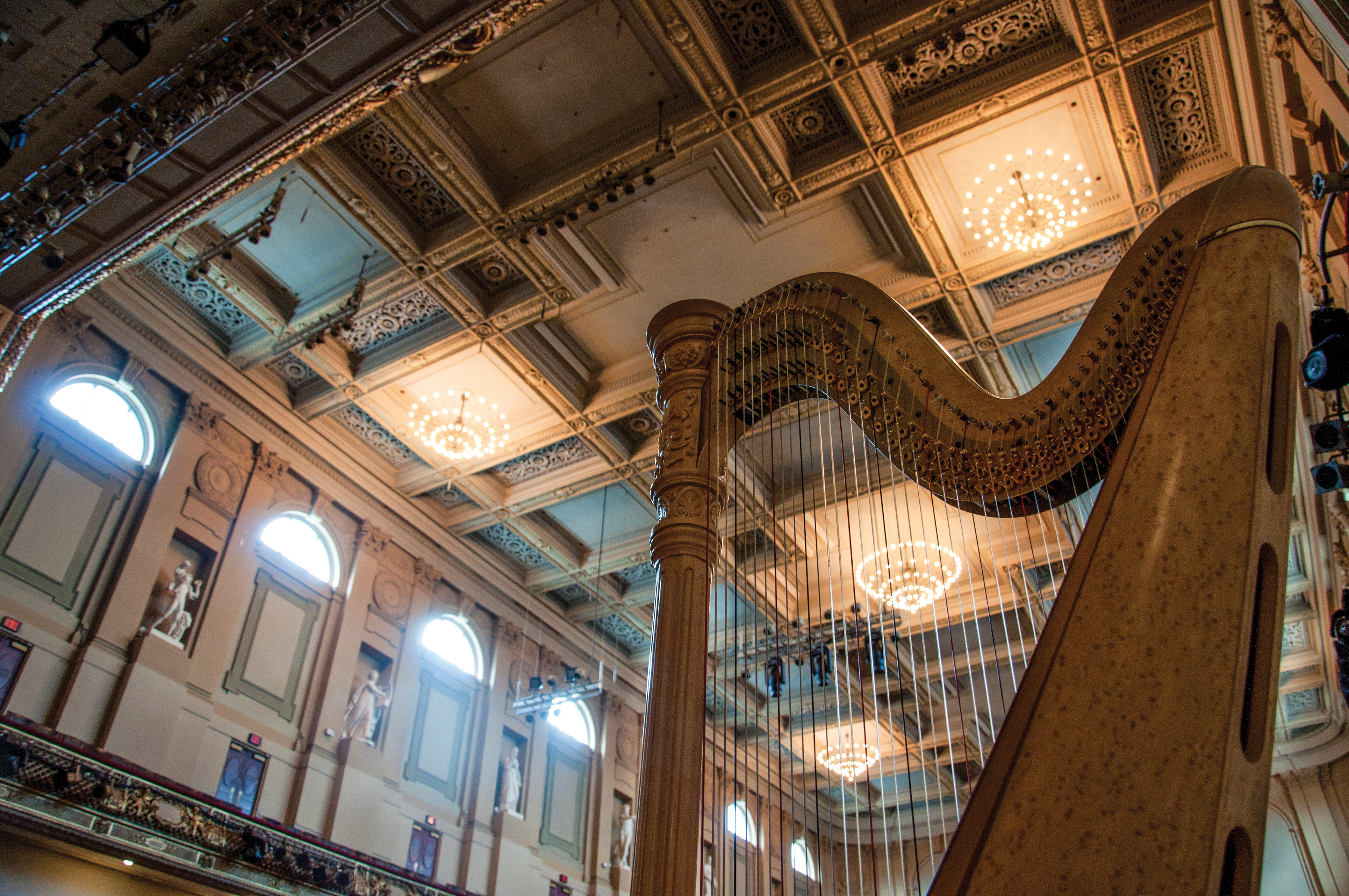 close up of a harp on stage at Symphony Hall in Boston with sunshine pouring in through the windows