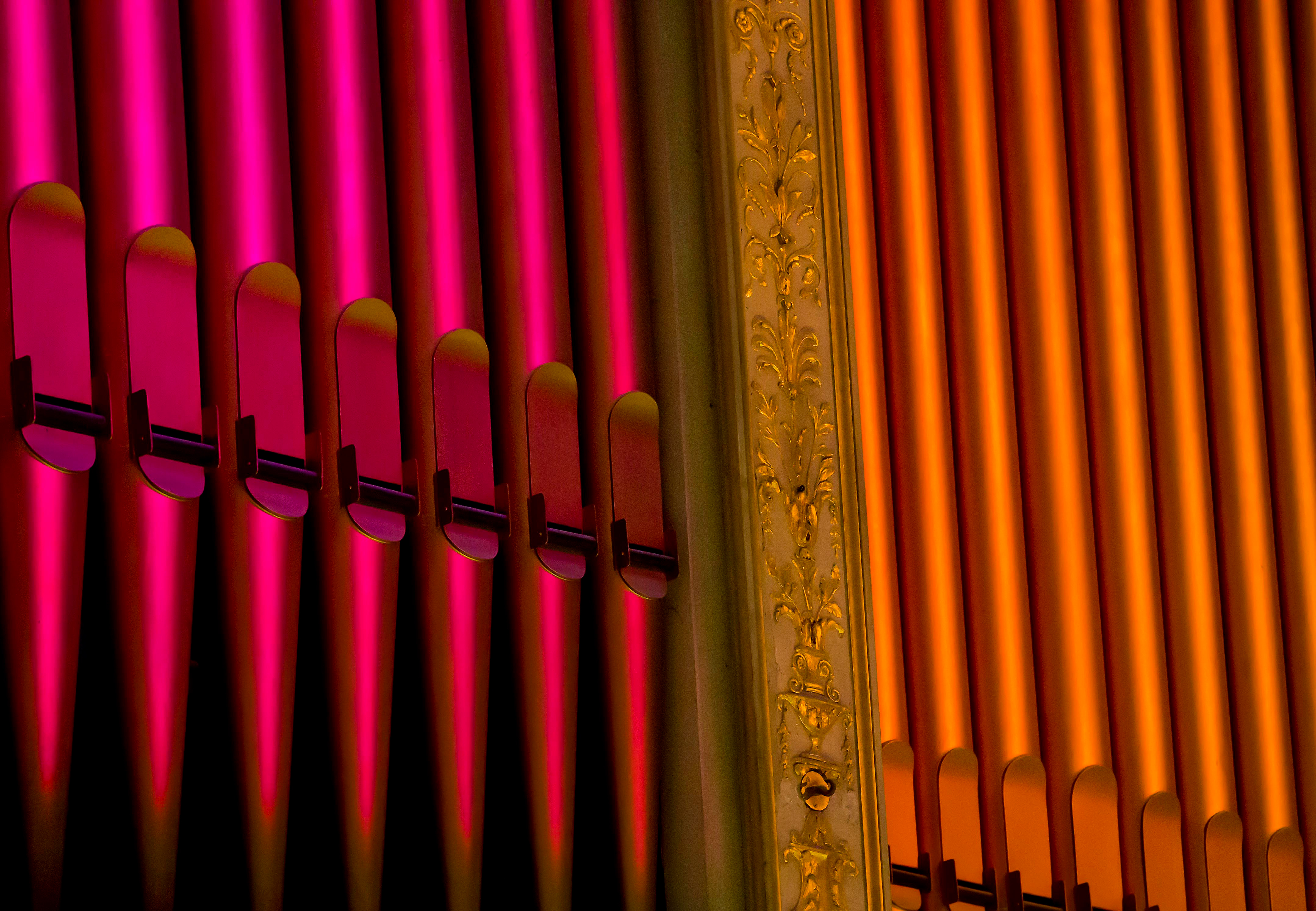 A close up of red and orange organ pipes