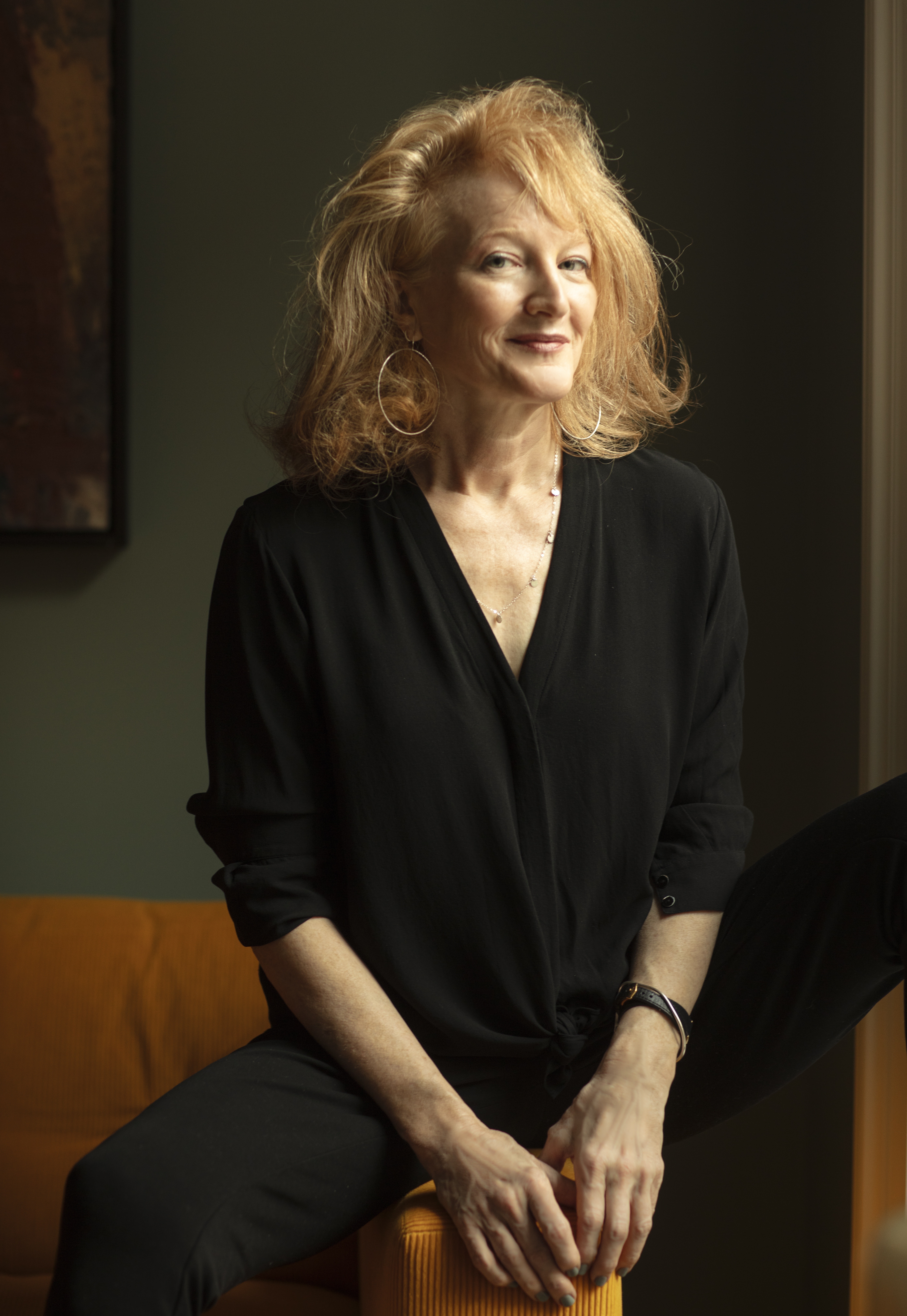 Krista Tippett sitting down wearing a black shirt and looking off into the distance