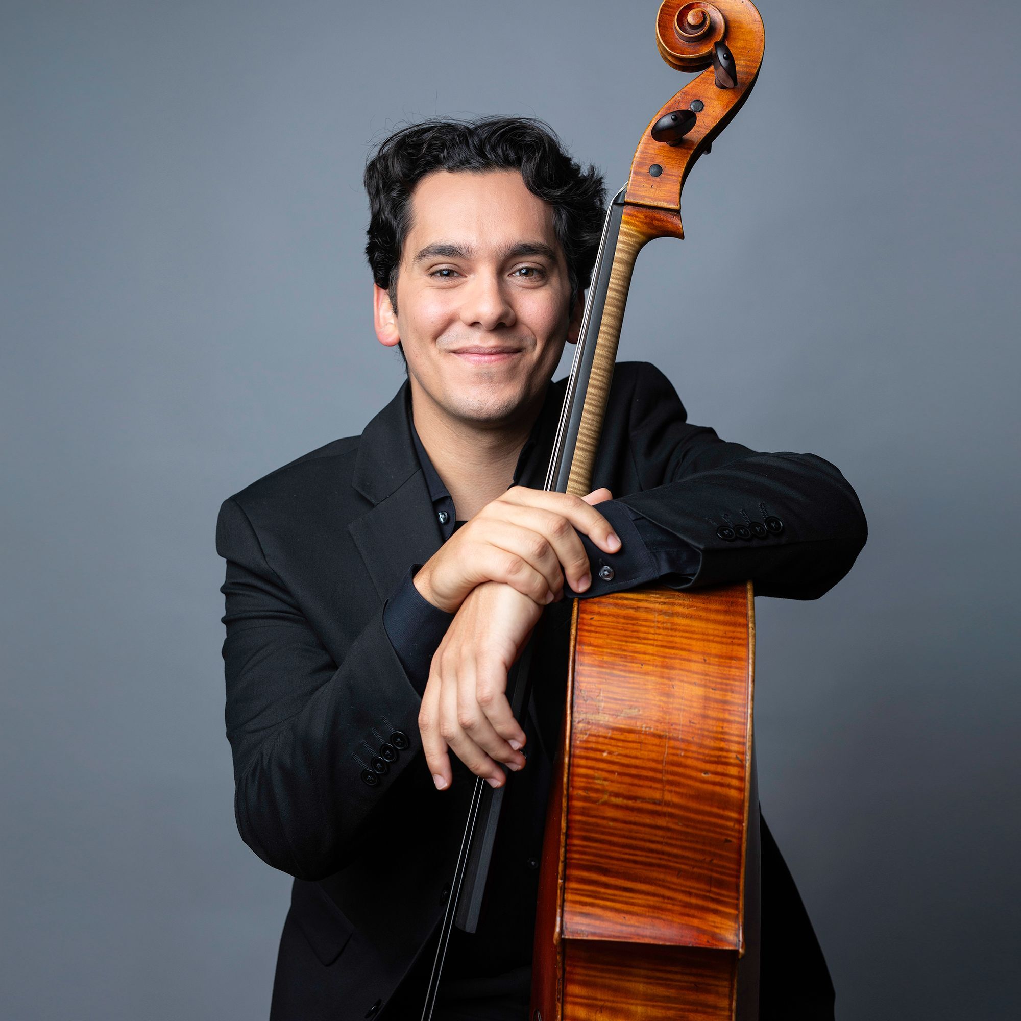 Max Oppeltz-Carroz headshot with cello