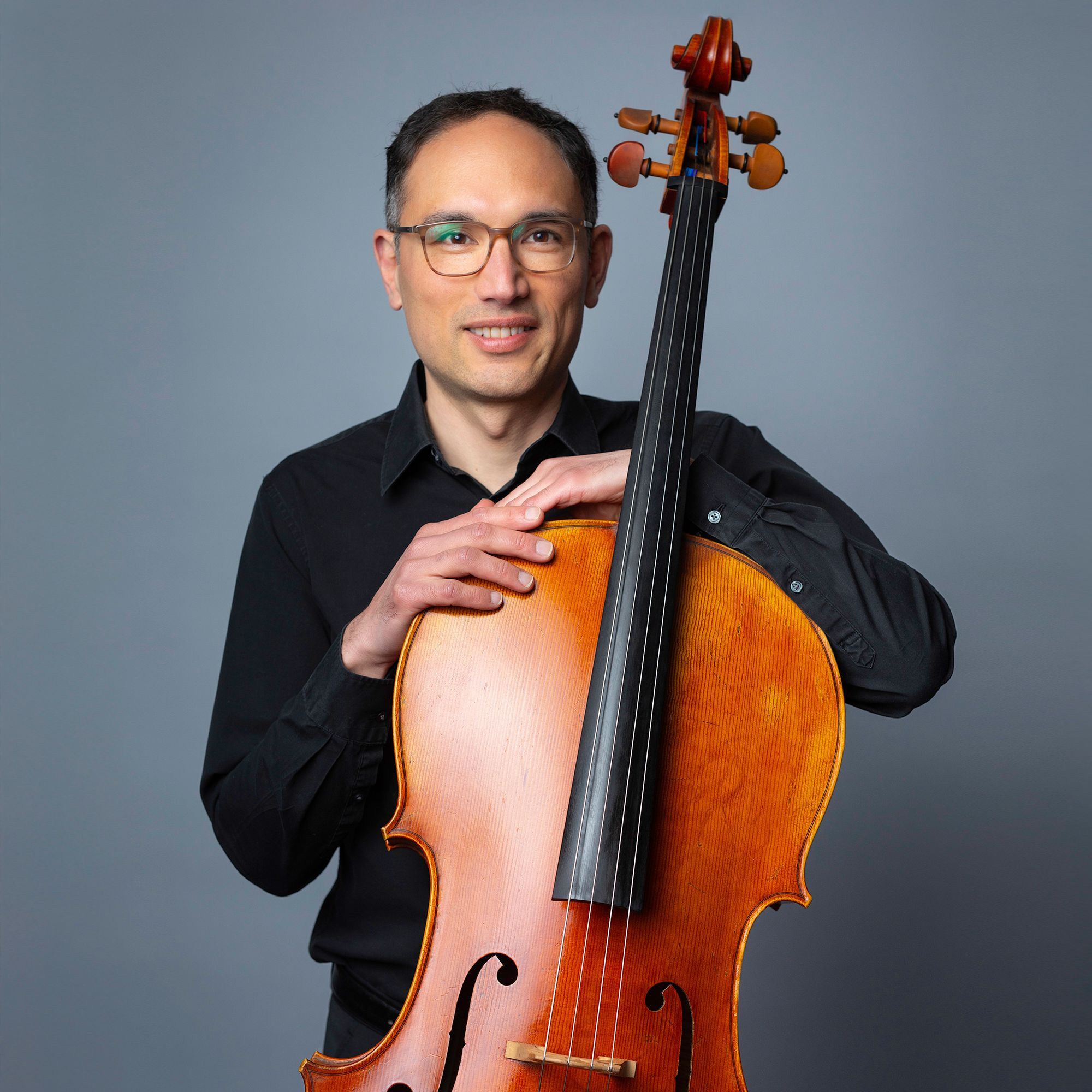 Adam Esbensen headshot with cello
