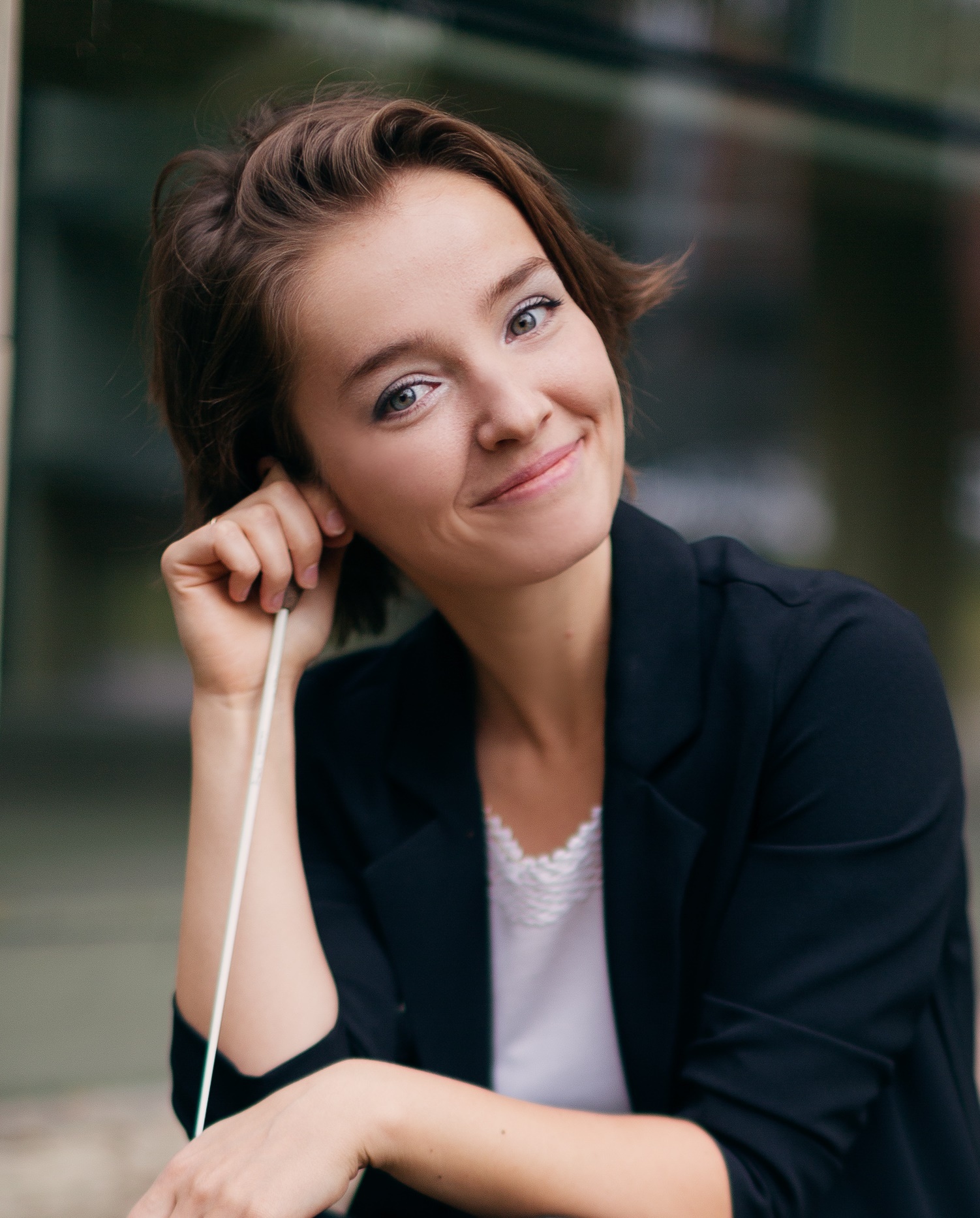 Anna Rakitina smiling and holding a conductor's baton