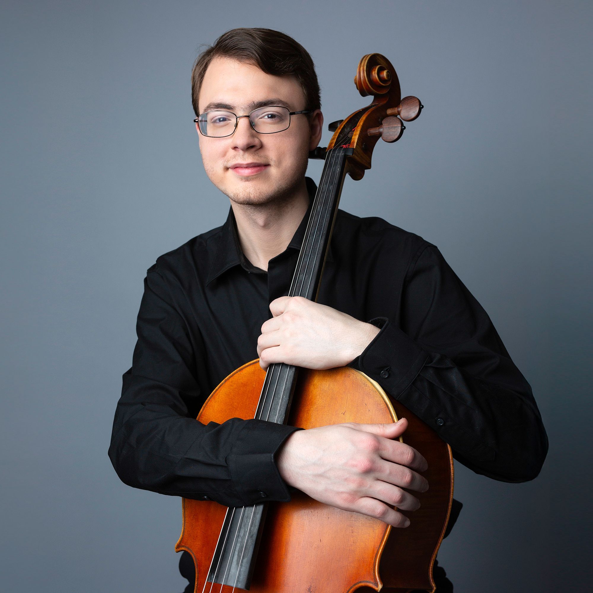 Roric Cunningham headshot with a cello