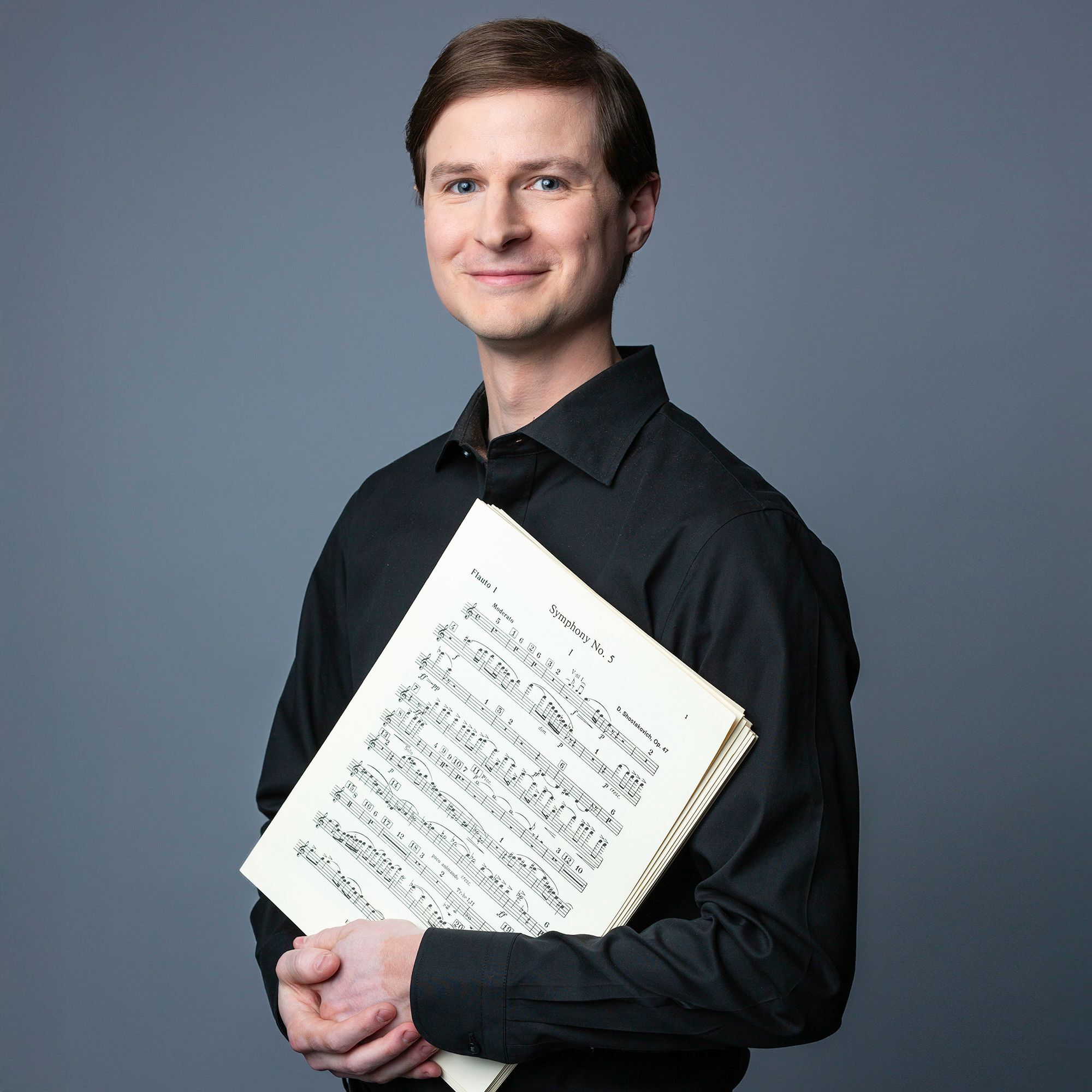 Russel Allyn headshot holding scores of music