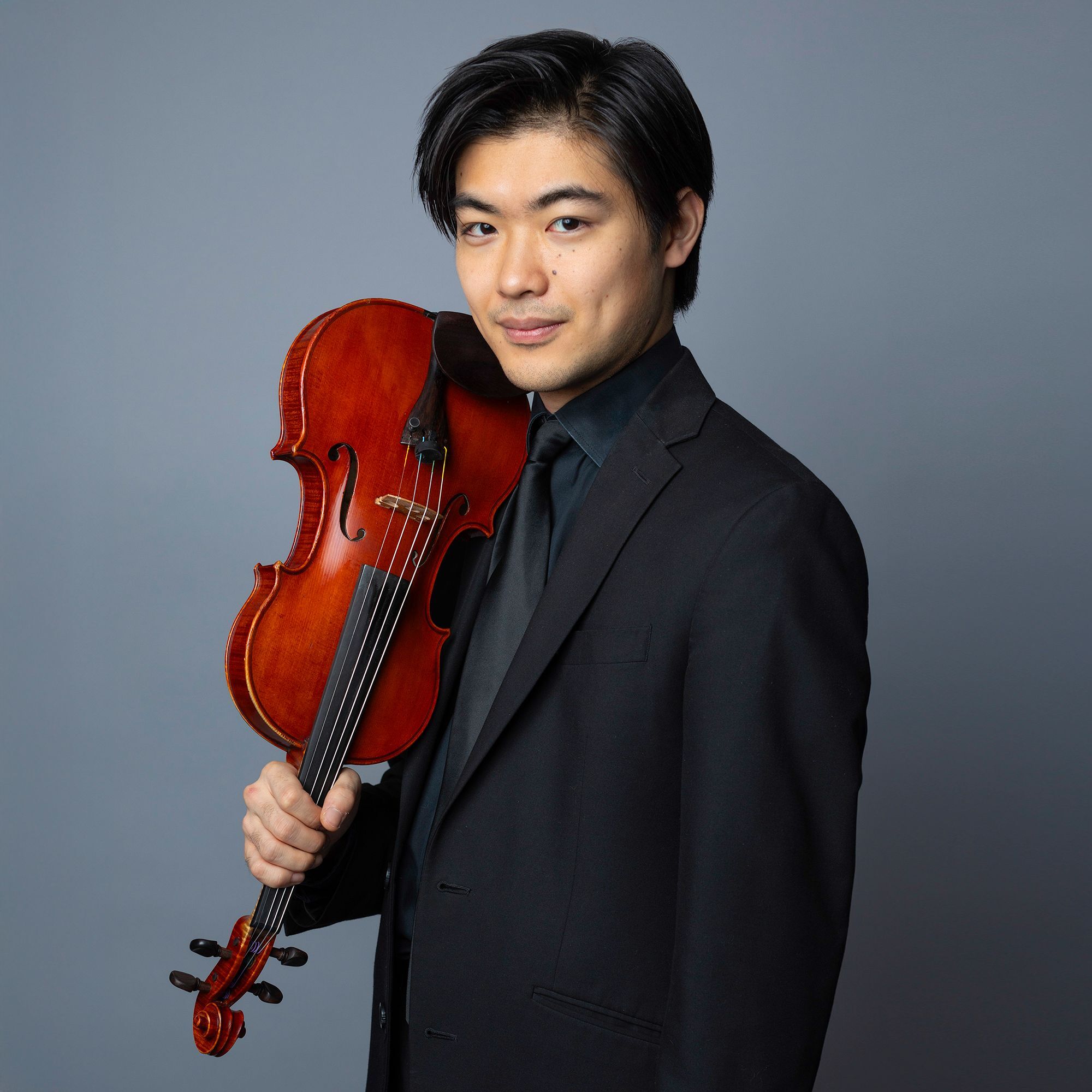 Takumi Taguchi headshot holding a violin