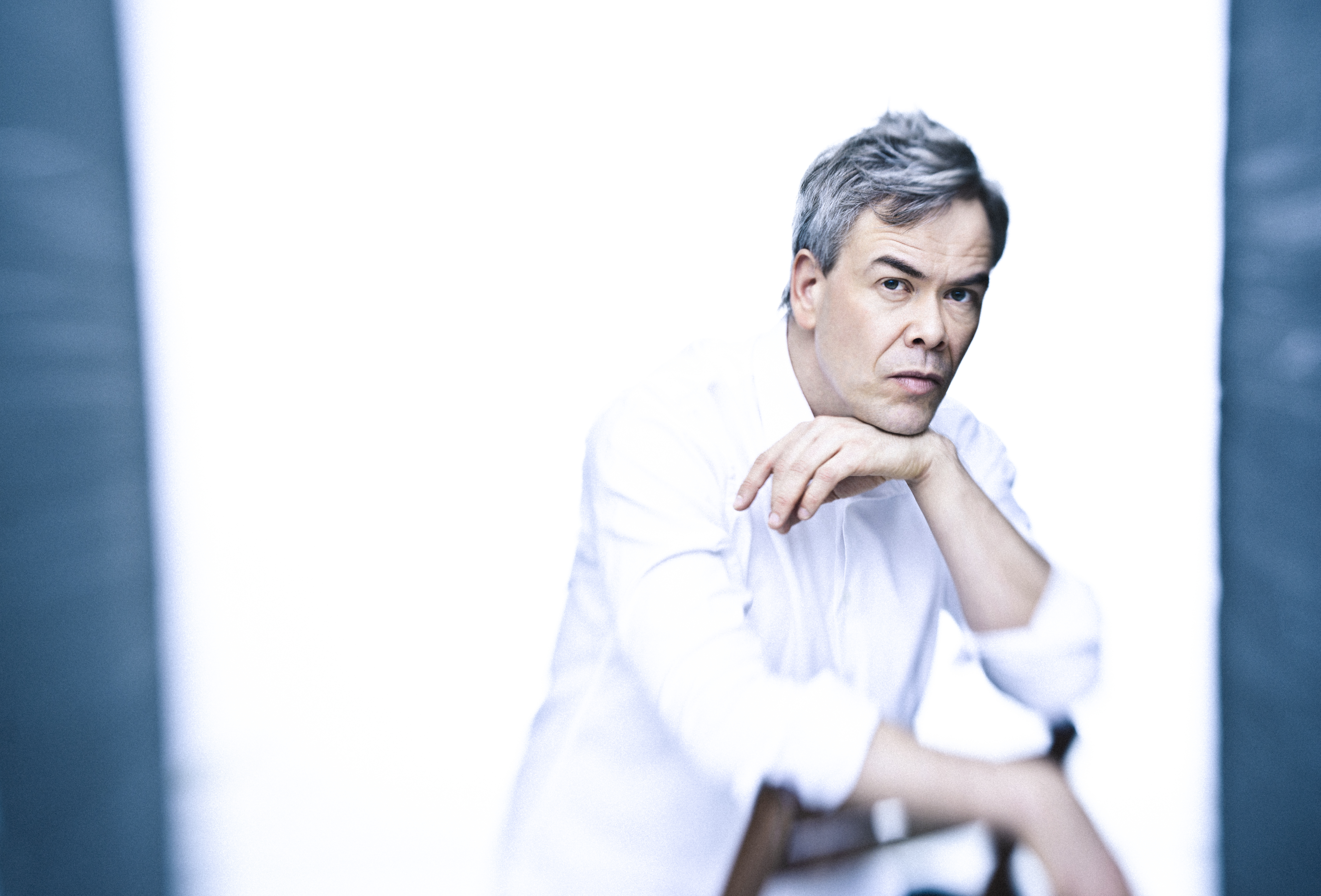 A headshot of Hanna Lintu sitting backwards on a chair wearing a white shirt