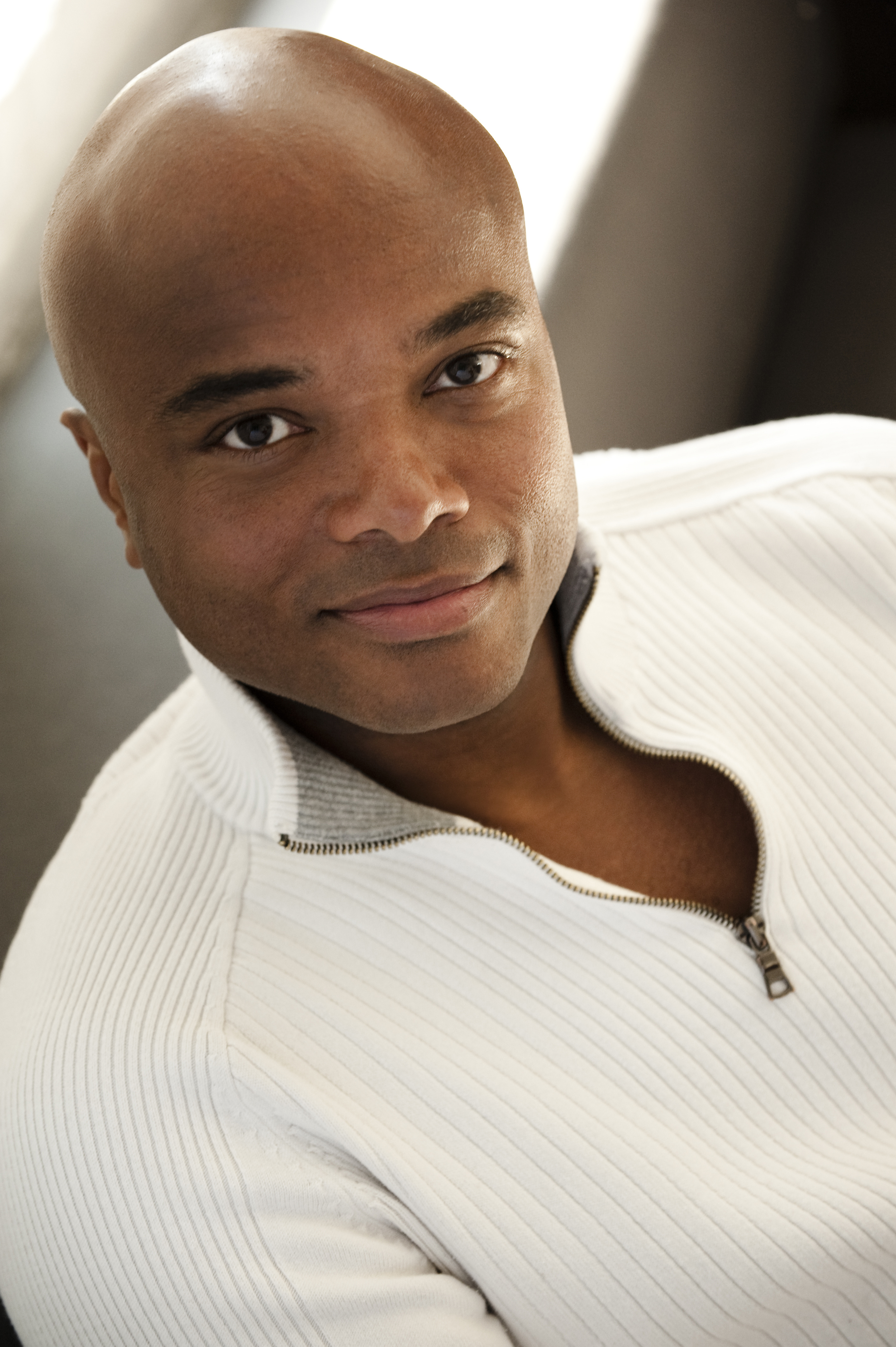 A headshot of Leon Williams wearing a white sweater