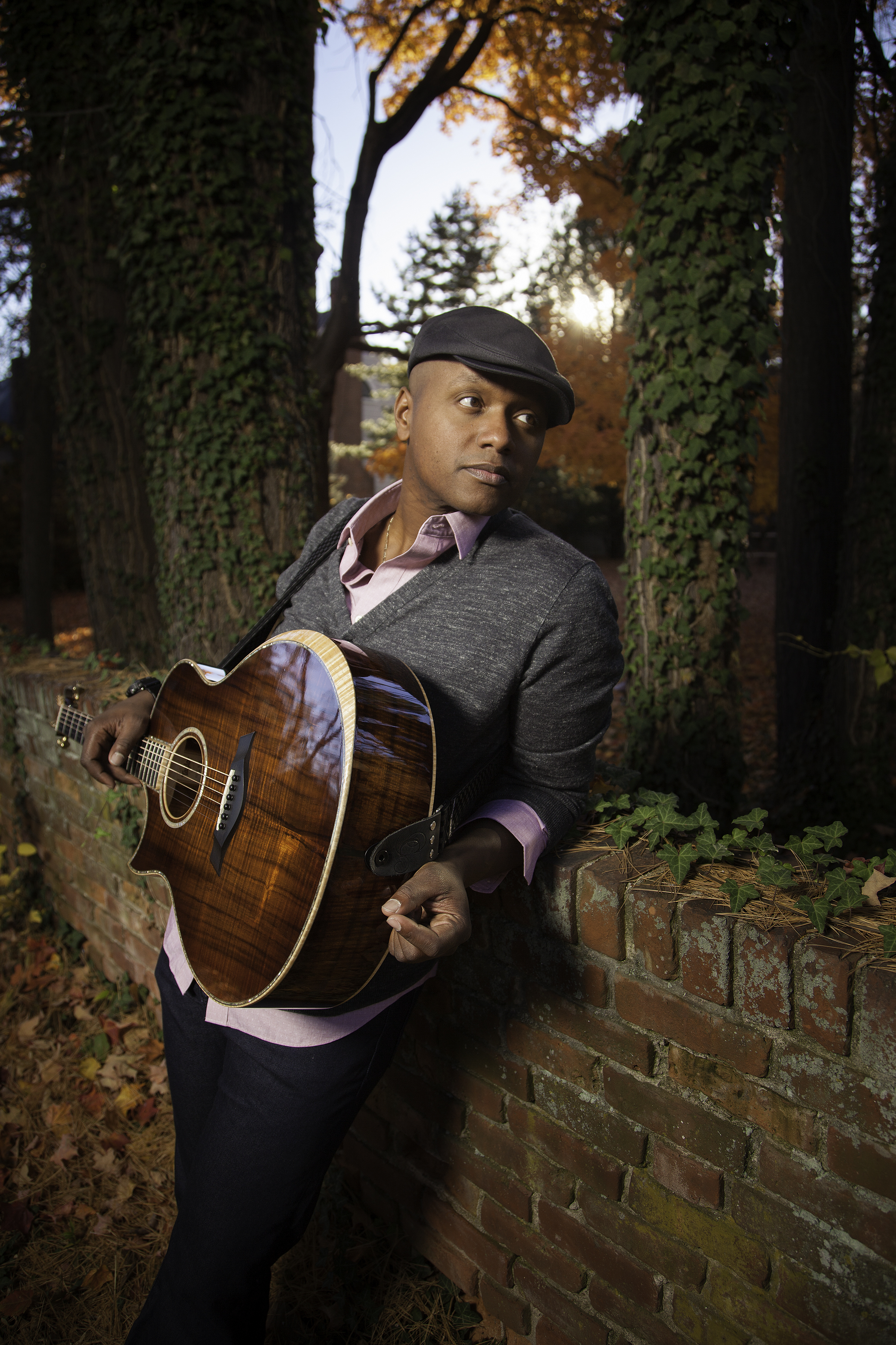 Javier Colon holding a guitar and looking to his left over his shoulder