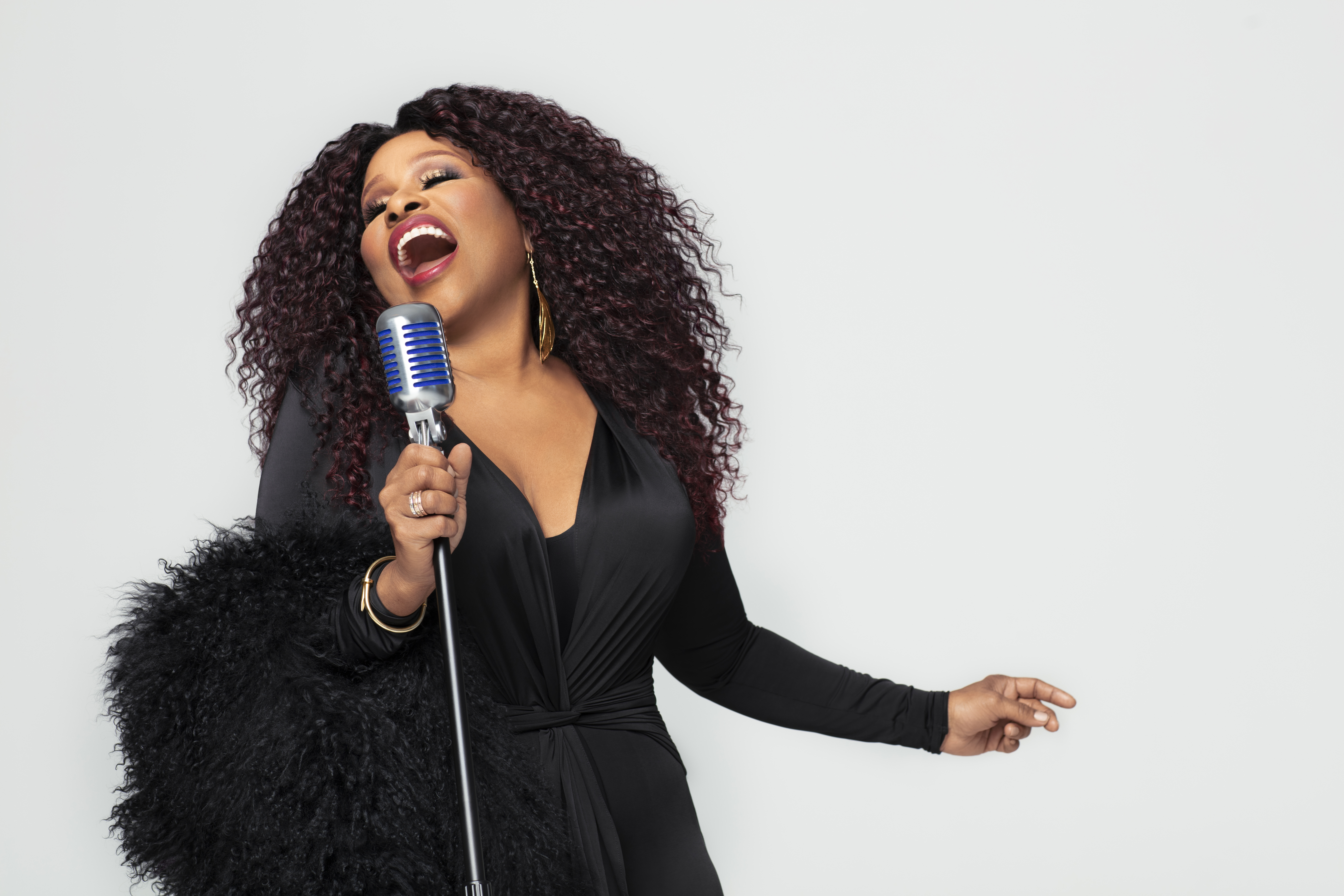 Chaka Khan sining into a vintage microphone
