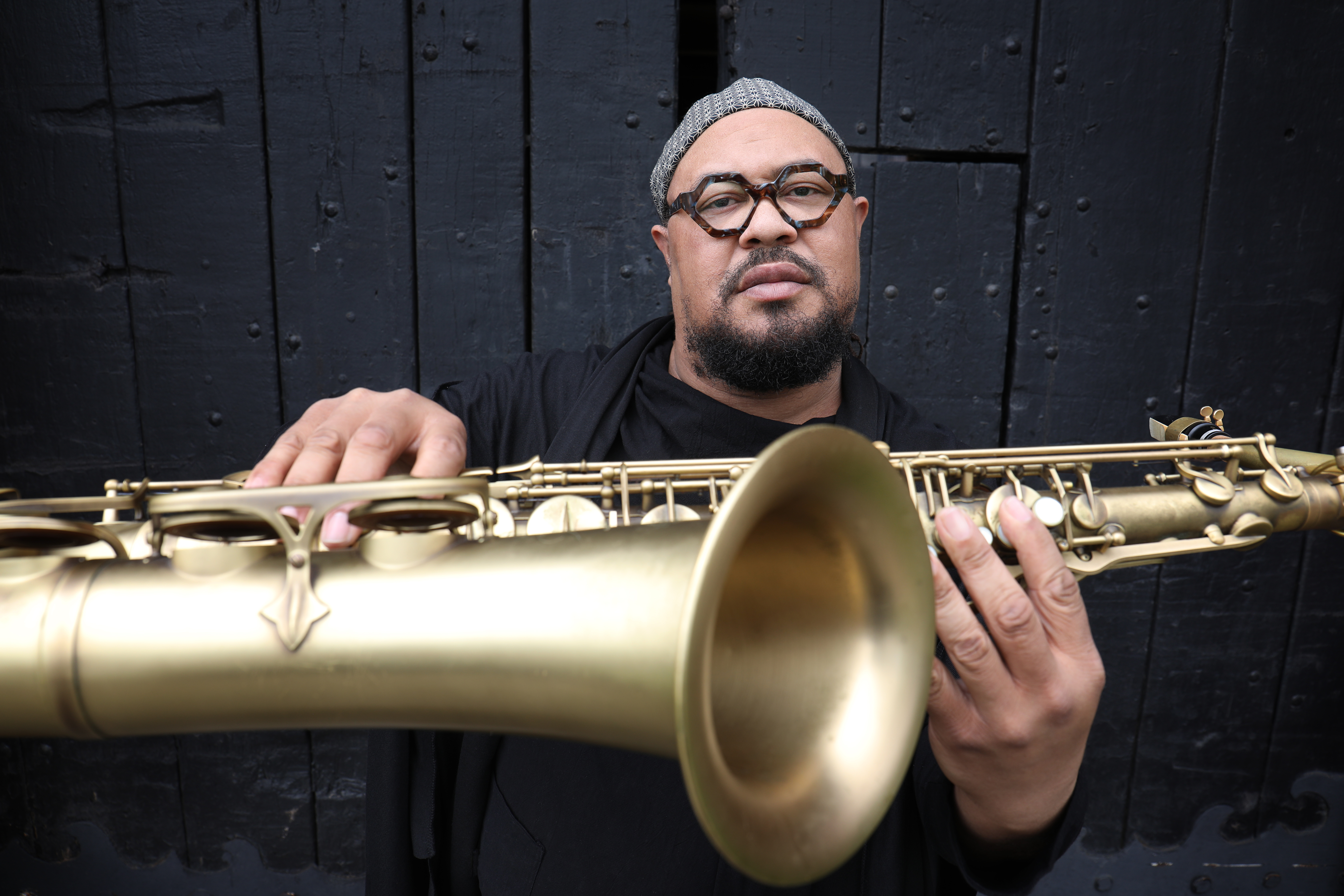 Dayna Stephens holding a saxophone horizontally