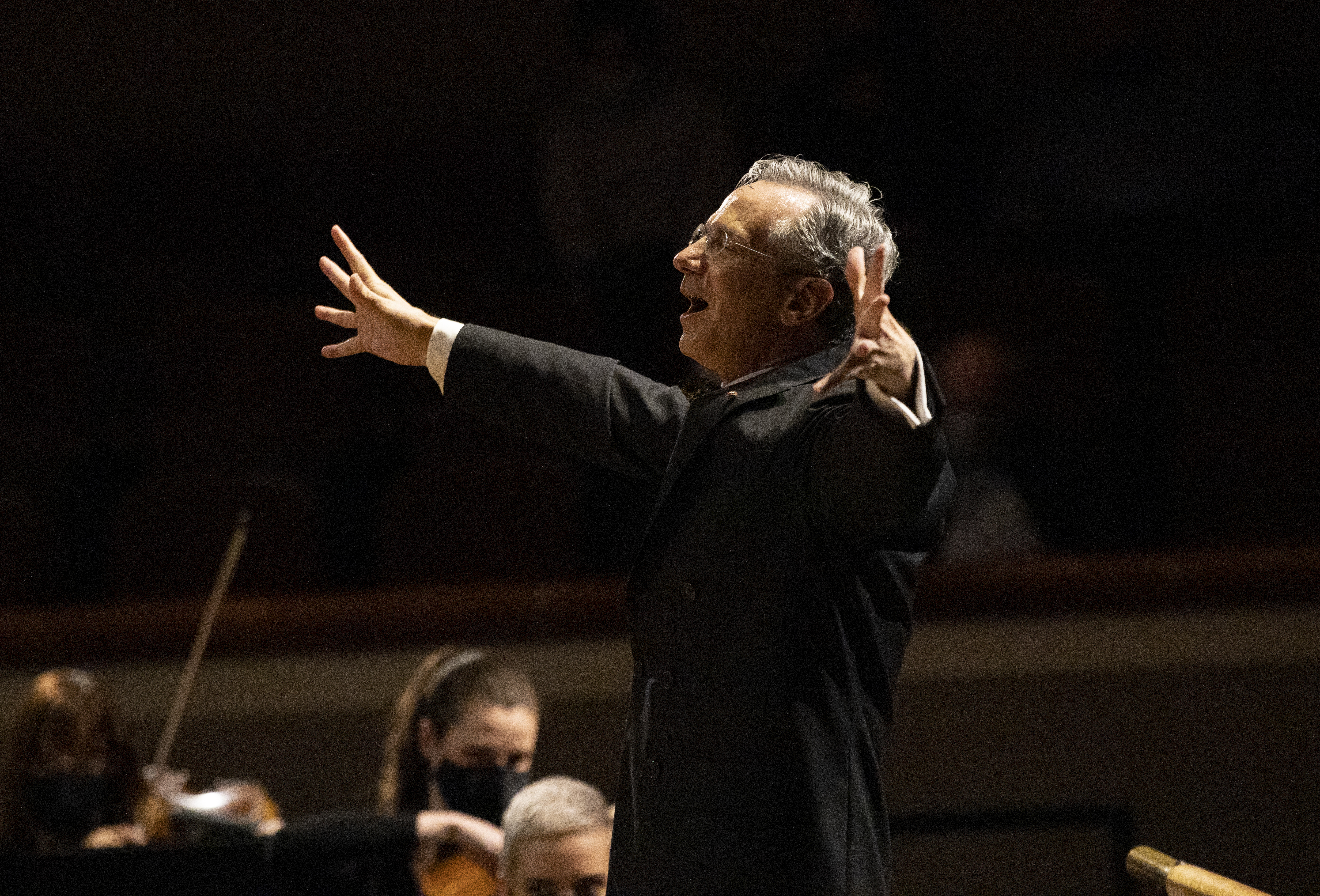 Fabio Luisi conducting with both of his arms outstretched
