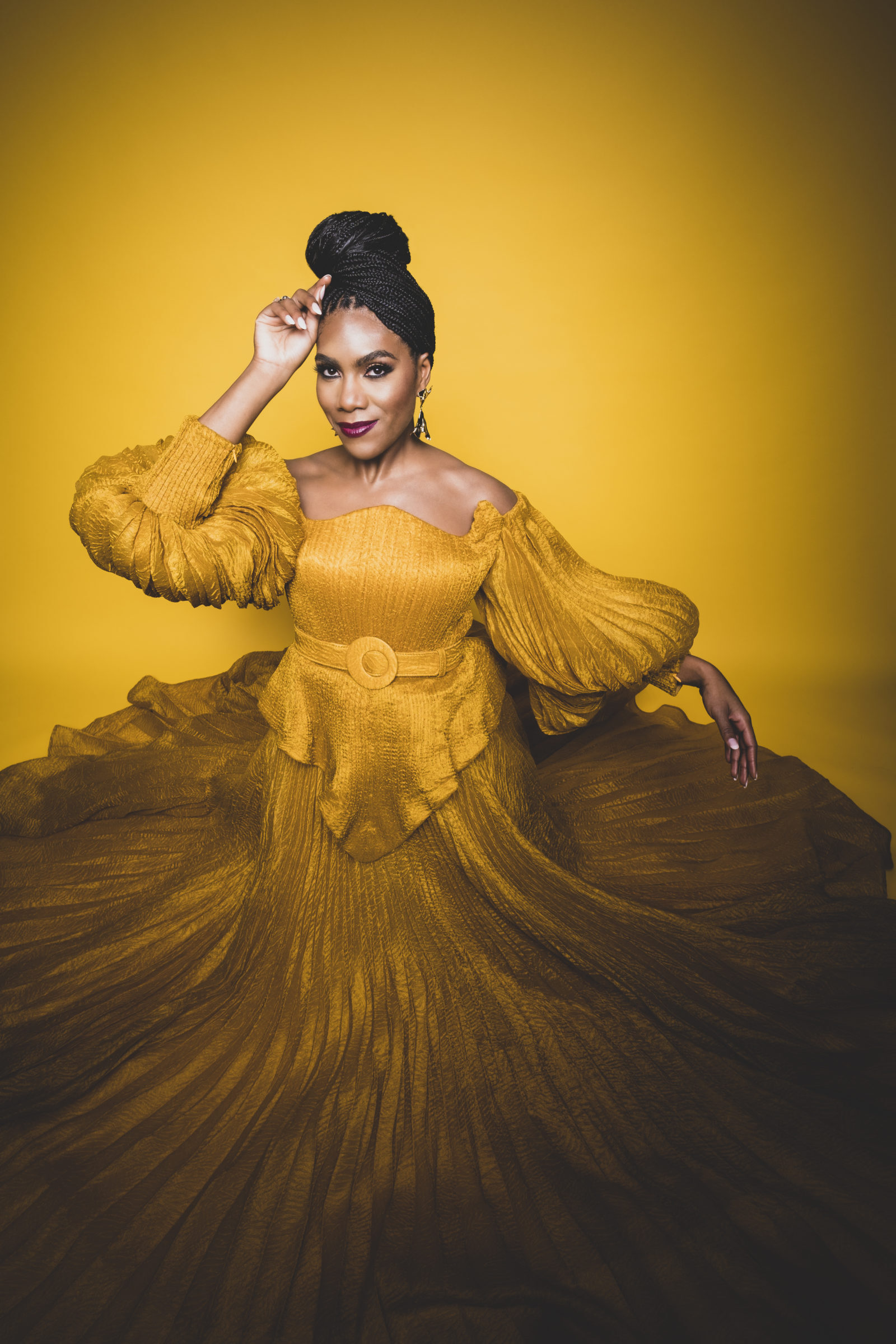 J'Nai Bridges wearing a marigold colored gown