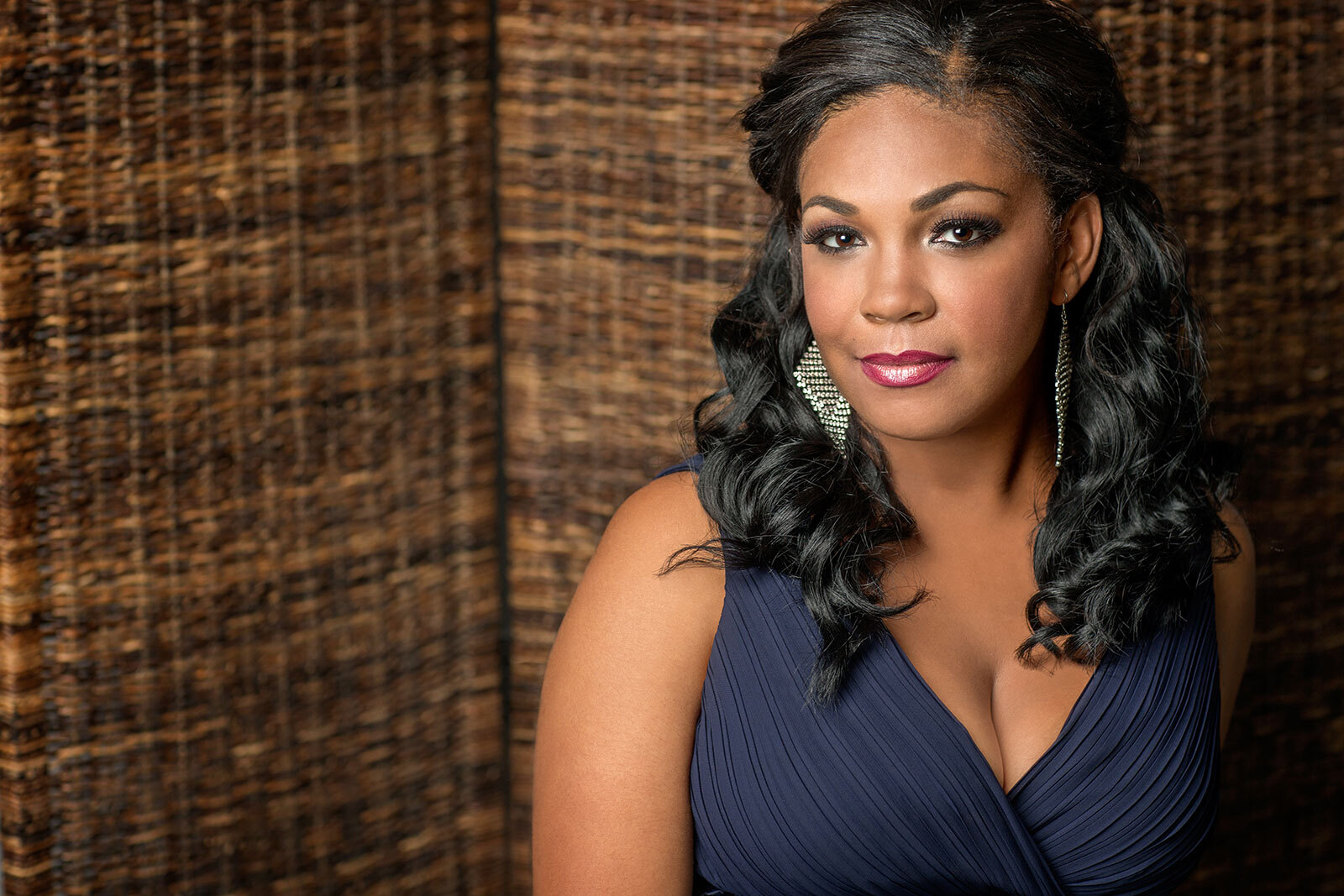 Jani Brugger standing in front of a large woven background