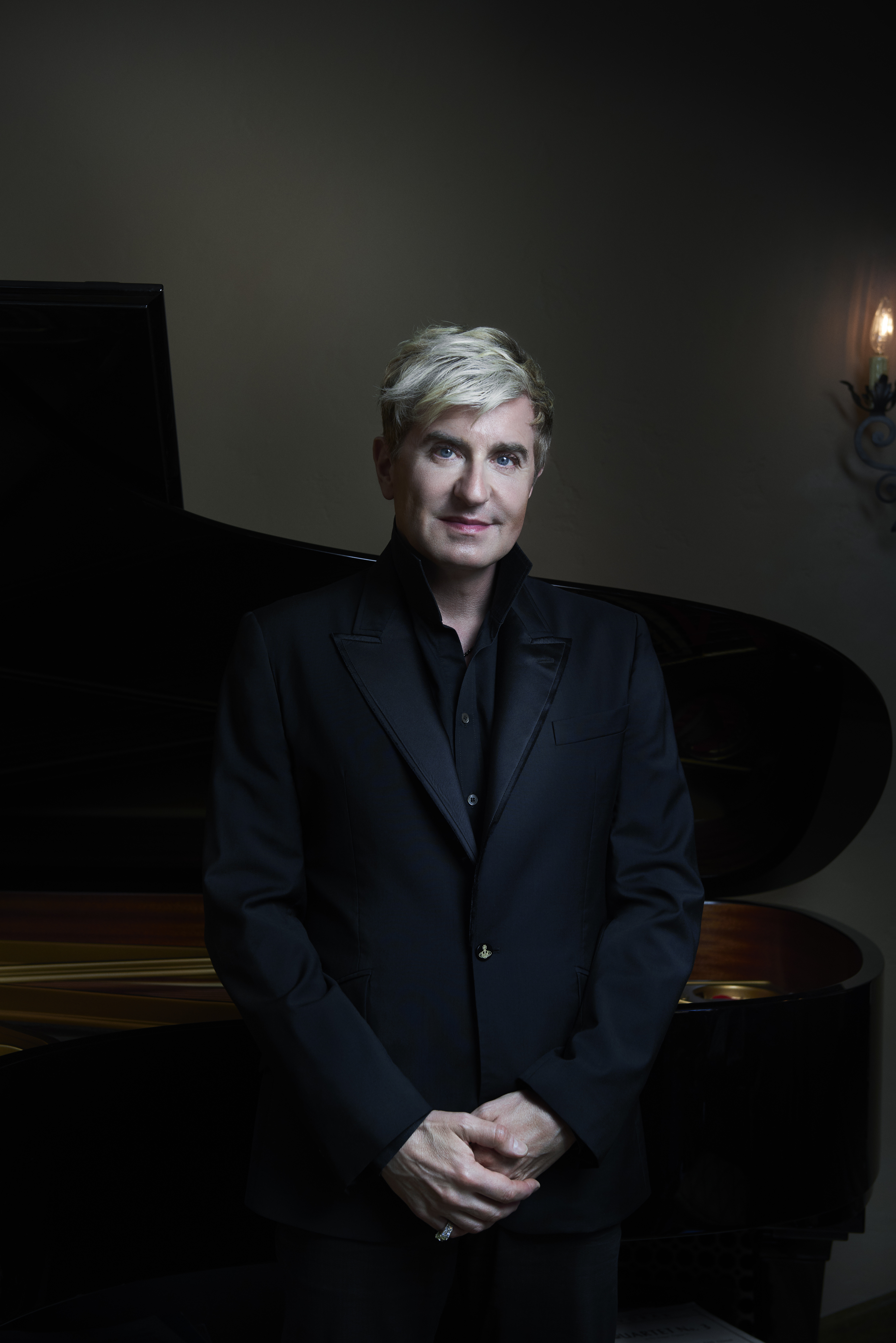 Jean-Yves Thibaudet standing in front of a piano, wearing all black