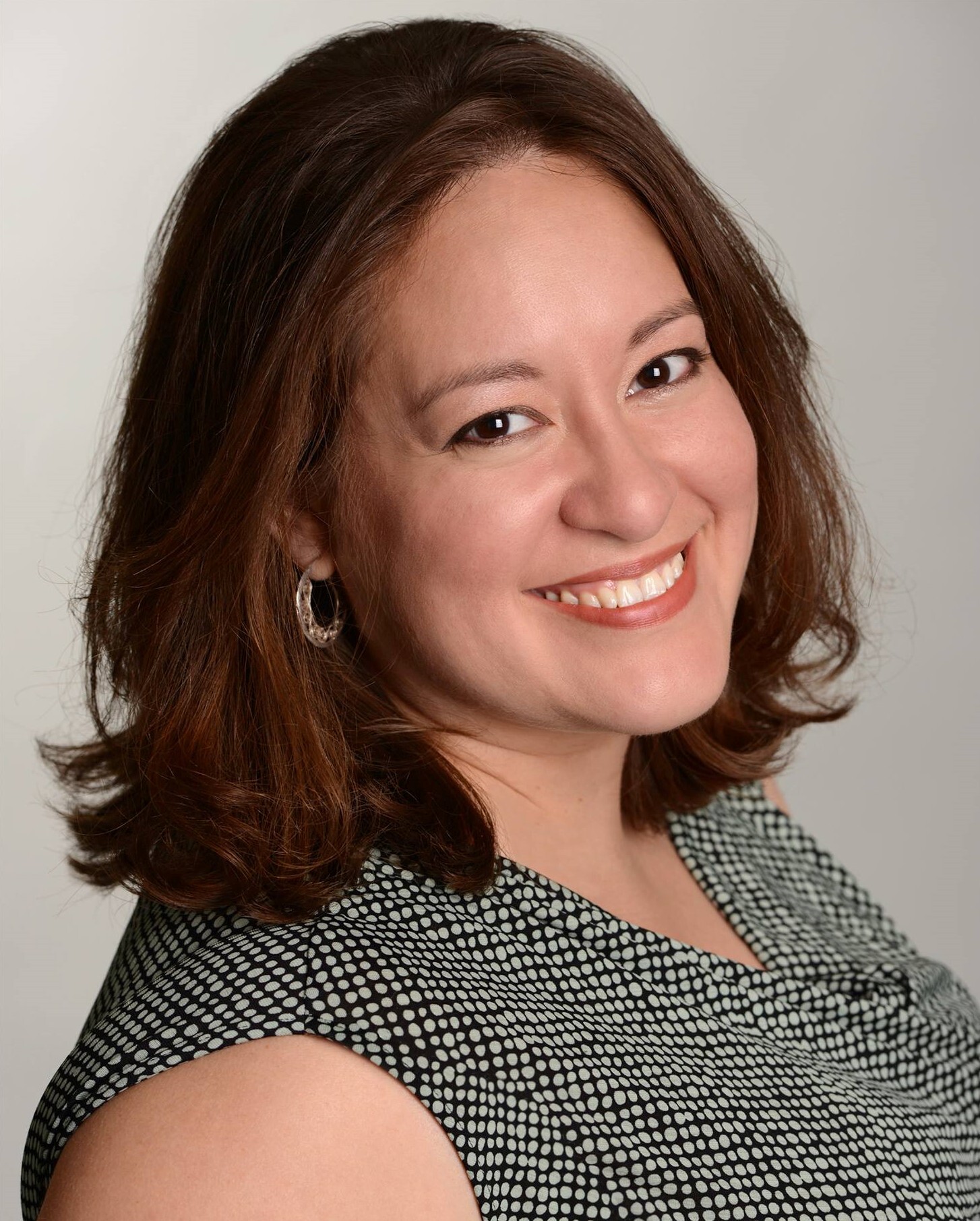 Karina Beleno smiling and wearing a green dress