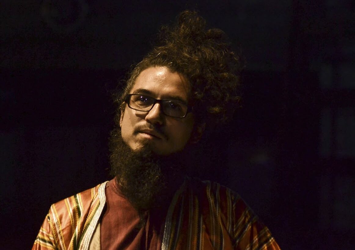 A headshot of Leo Genovese against a dark background