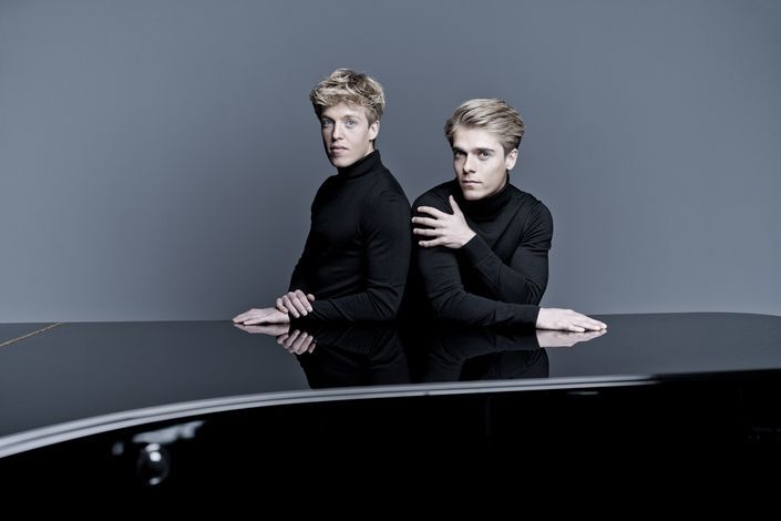 Lucas Arthur Jussen sitting in front of a piano, wearing all black