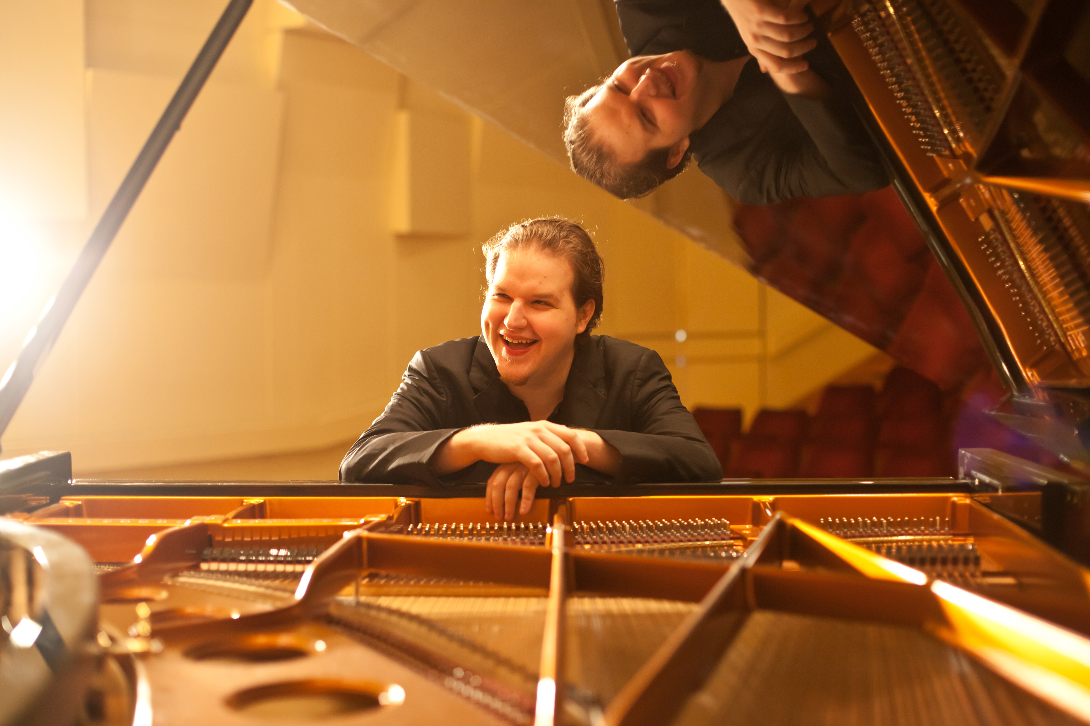 Photo of Lukáš Vondráček sitting at the piano from the perspective of inside the piano