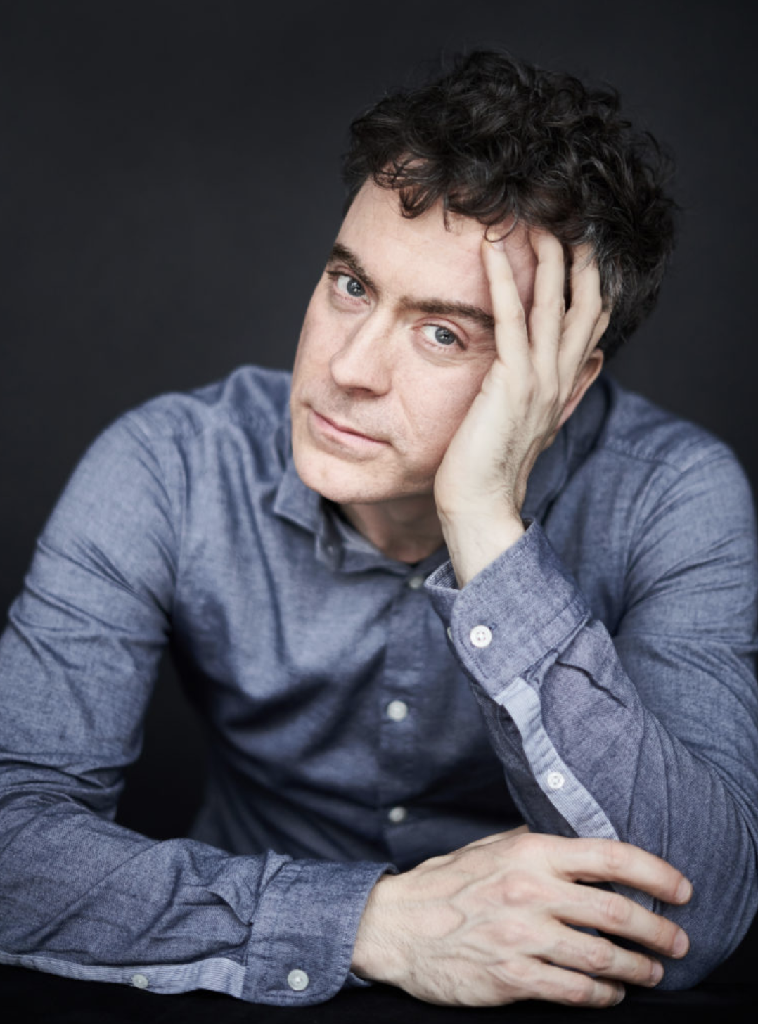 Paul Lewis sitting with his head resting in his left hand