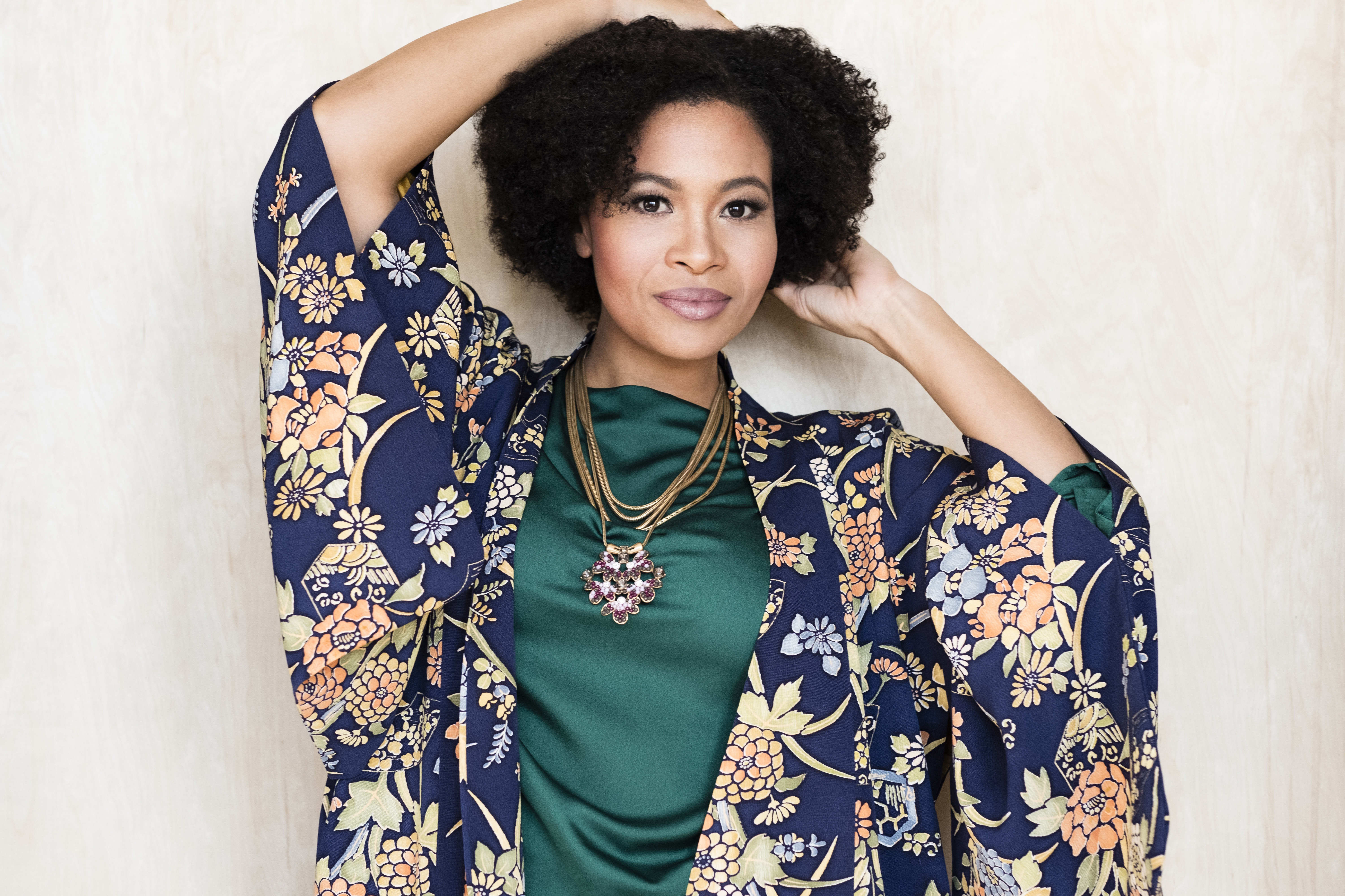 Portrait of Golda Schultz in an emerald green top and floral silk jacket