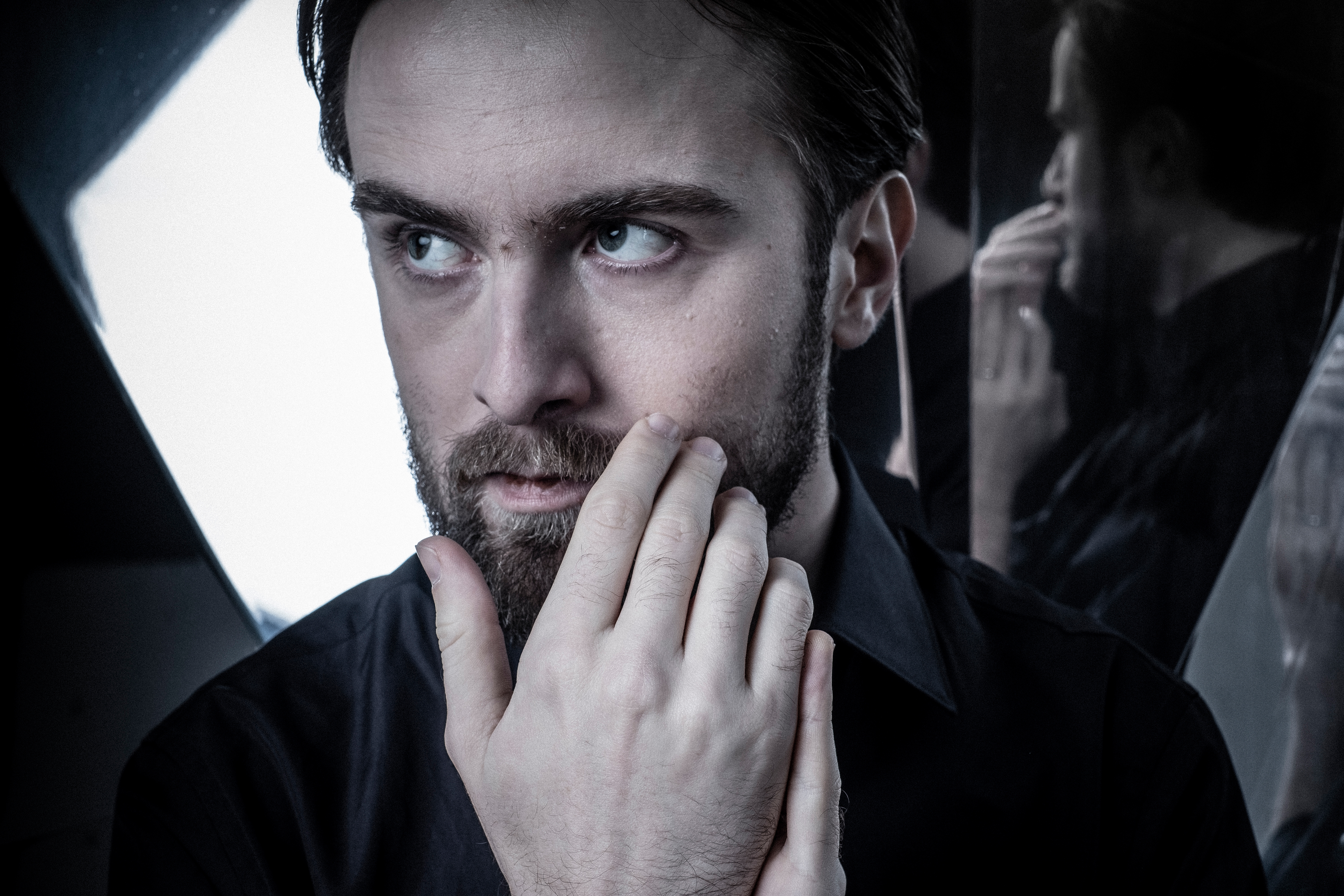 Daniil Trifonov standing in front of a mirror with his hands in front of his face