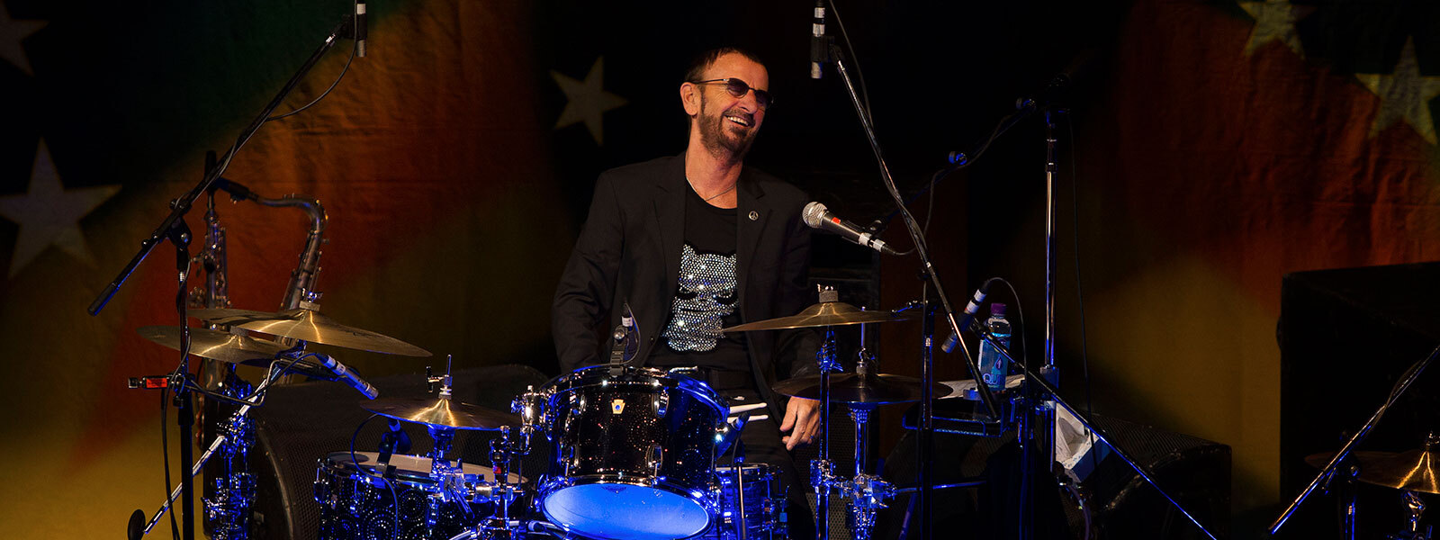 Ringo Starr sitting behind a drum kit, smiling