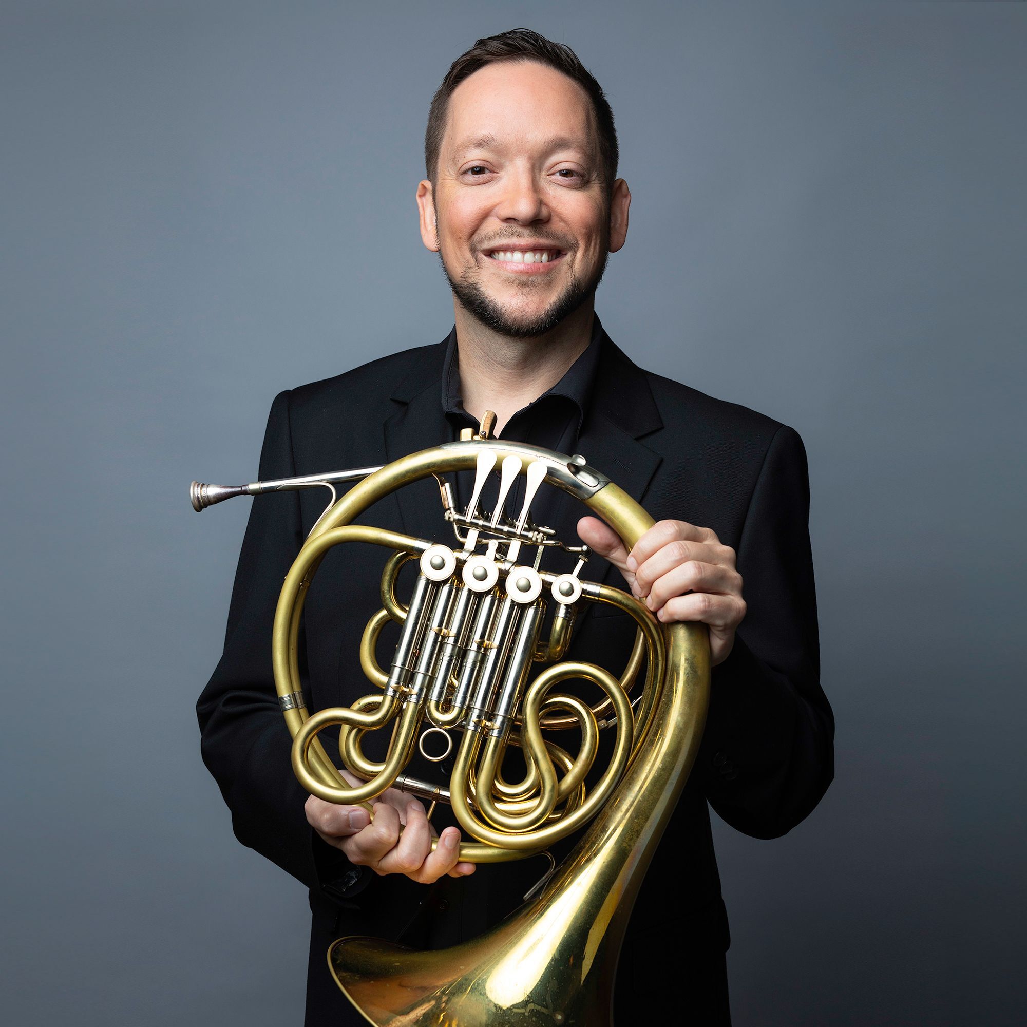 Jason Snider headshot with French Horn