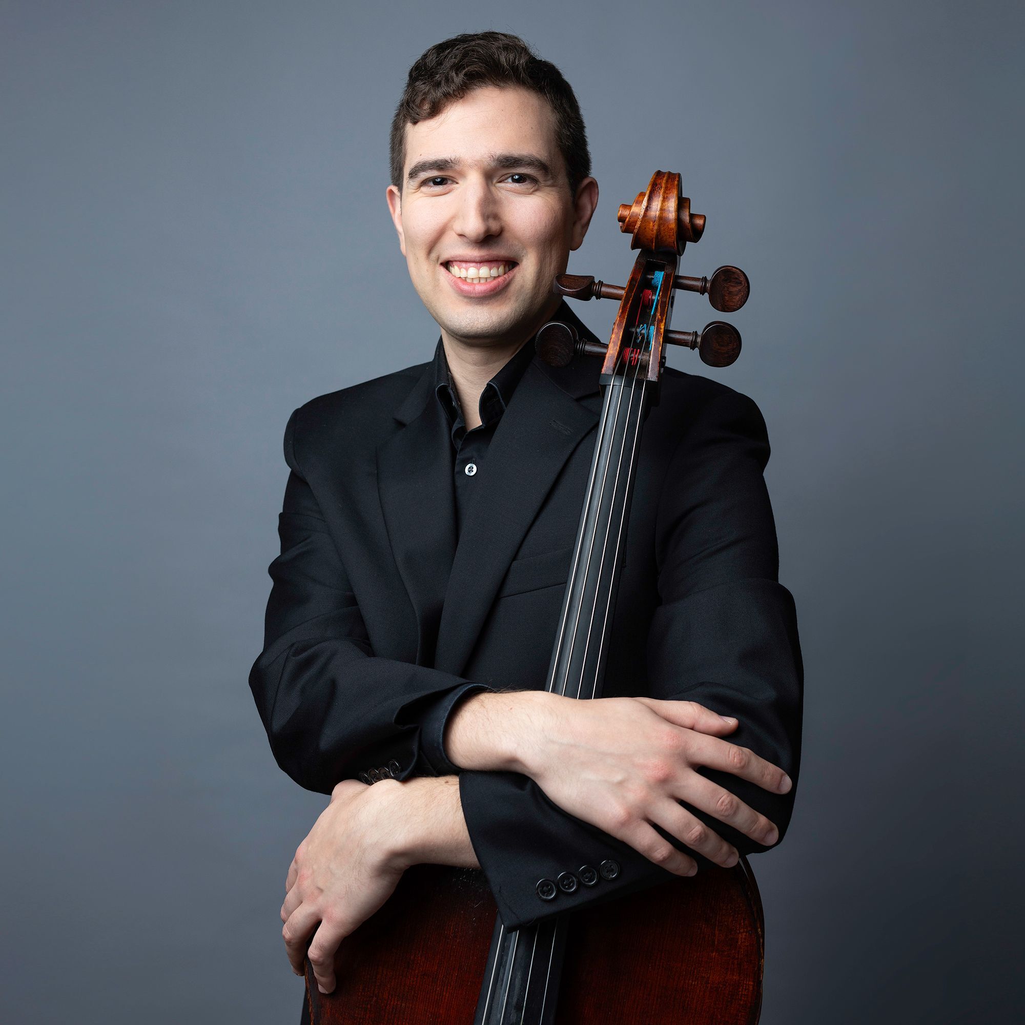 Oliver Aldort headshot with cello