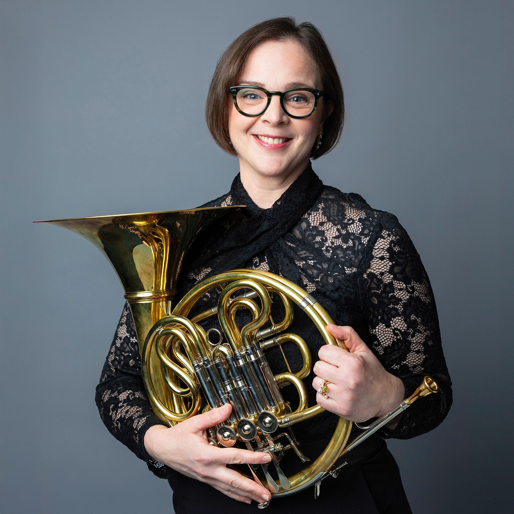Rachel Childers headshot with French Horn