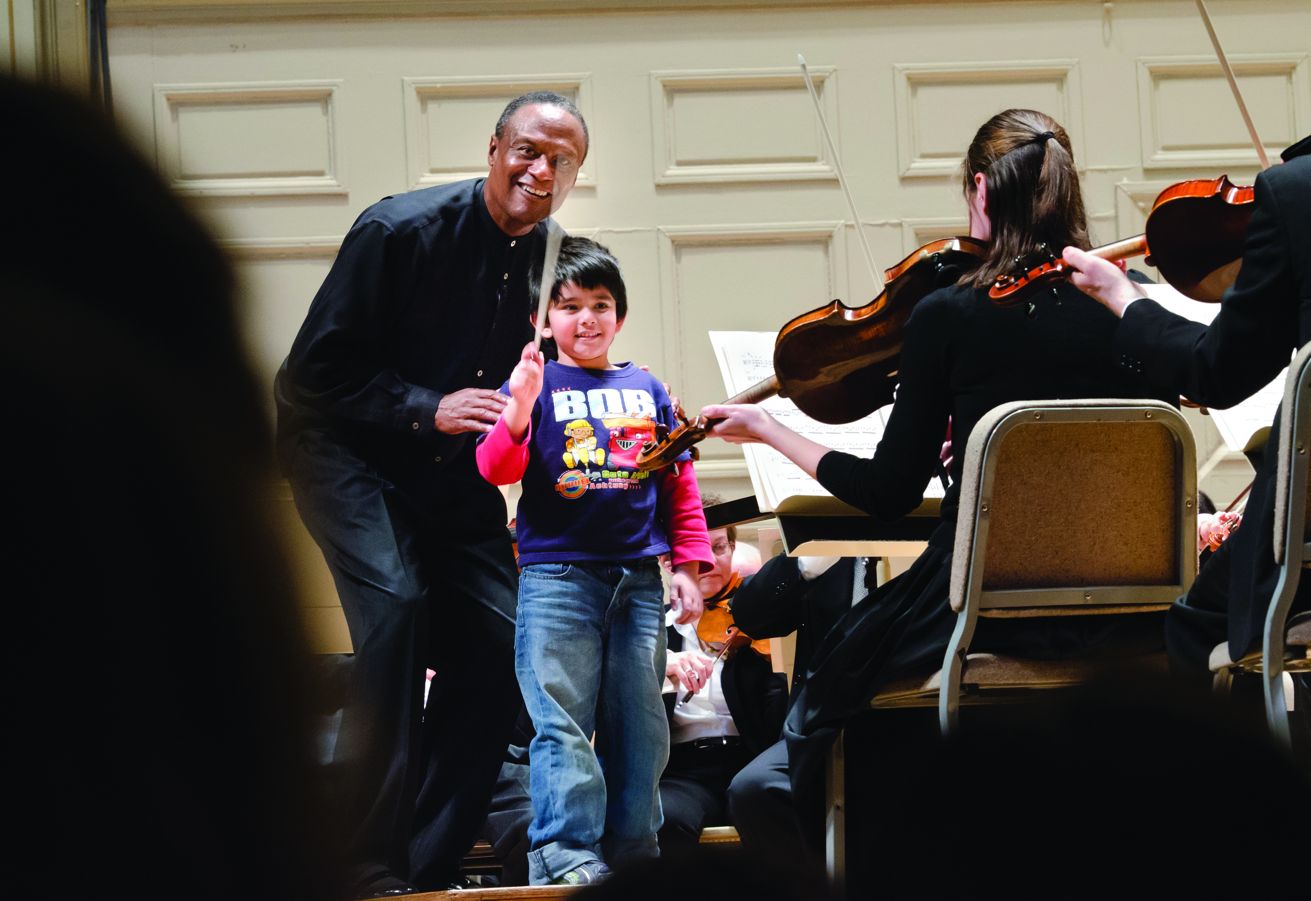 Thomas Wilkins teaching young boy how to conduct from the podium