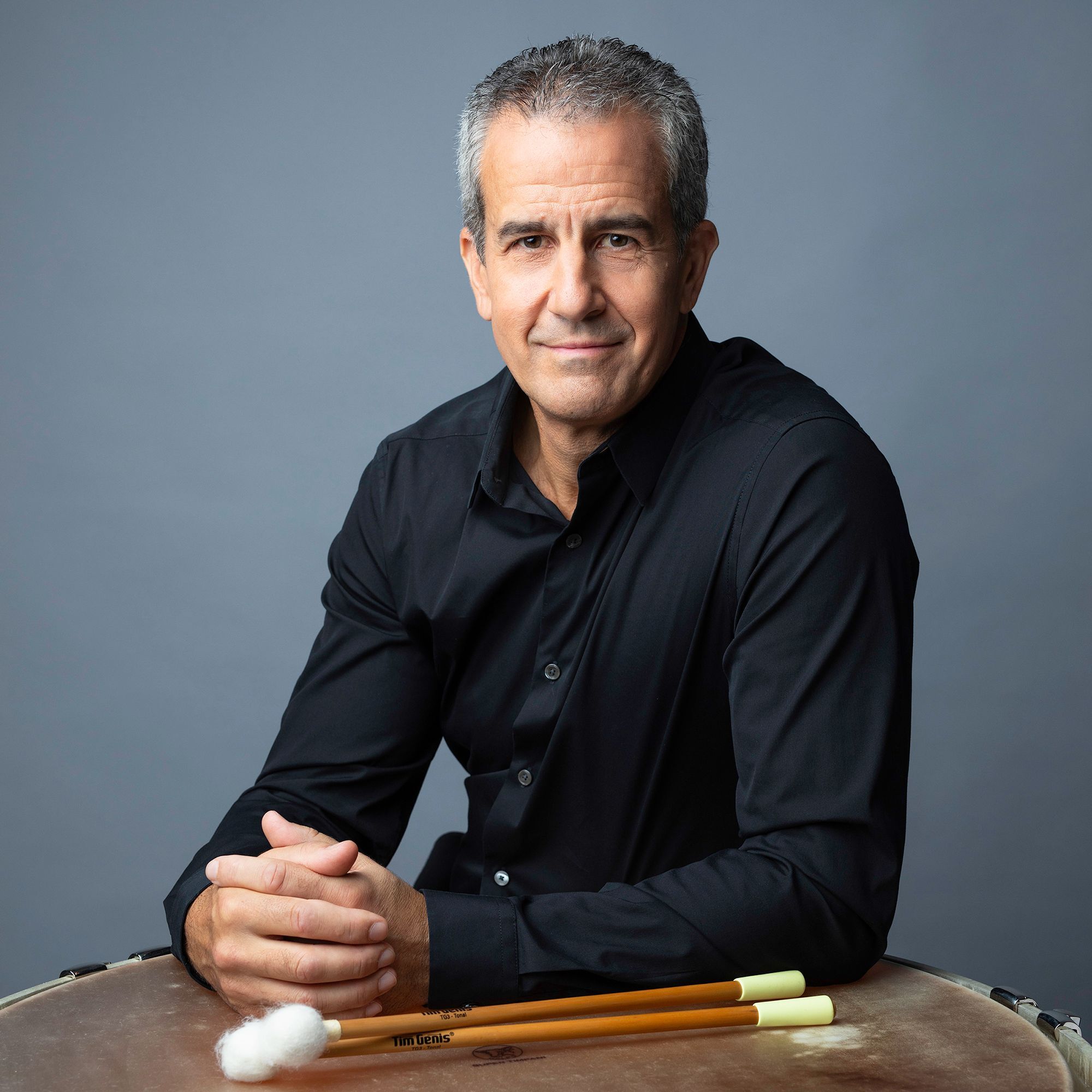 Timothy Genis headshot with timpani