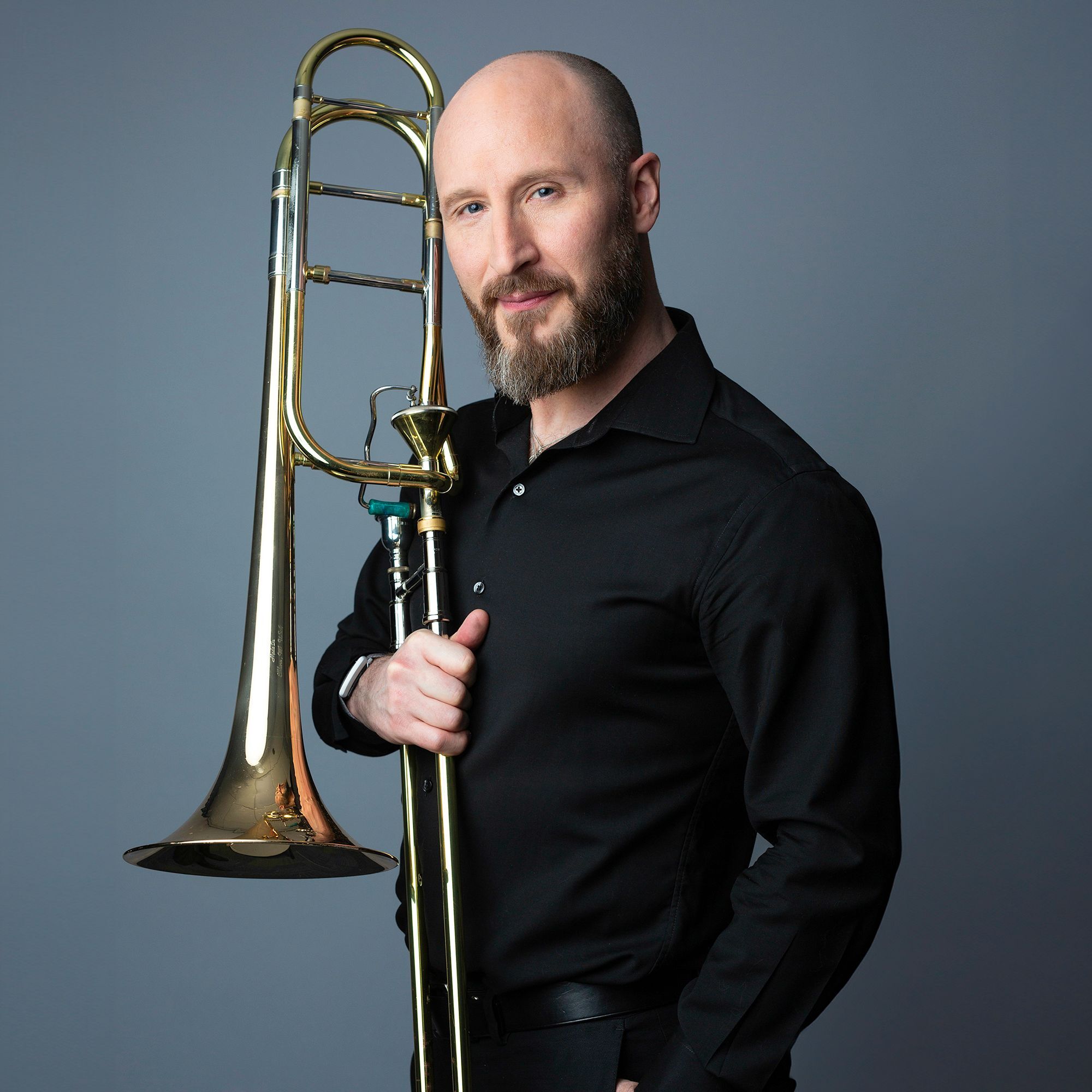 Toby Oft headshot with trombone